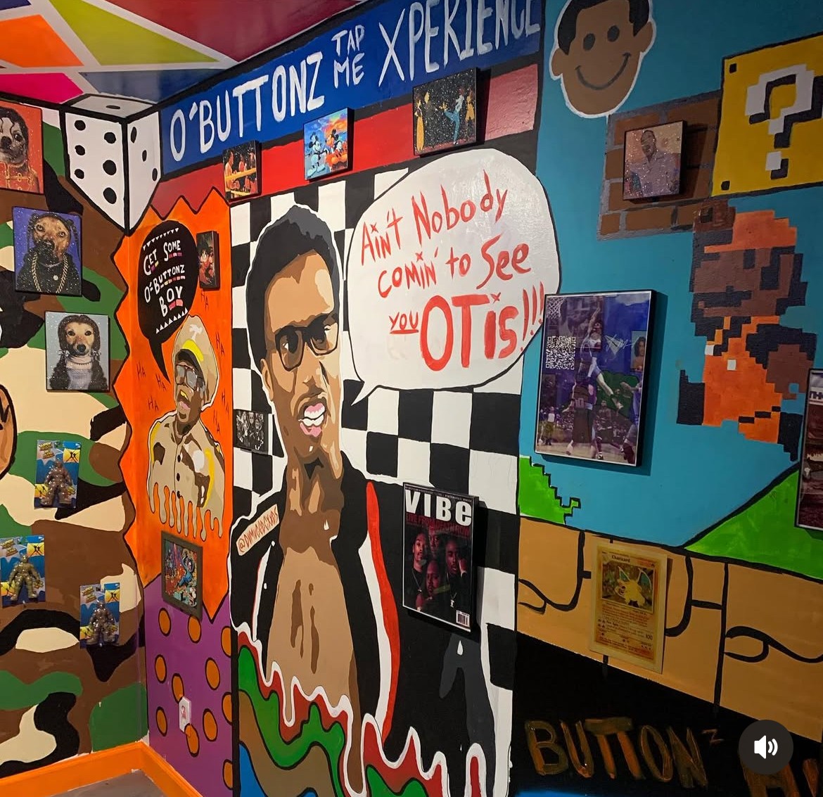 Colorful wall mural with a large portrait of a man wearing sunglasses, speech bubble, and various gaming and pop culture elements.