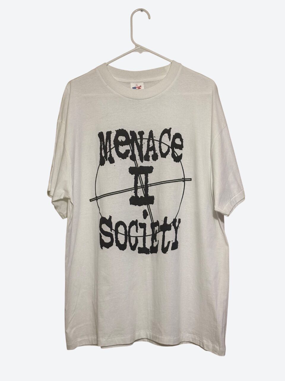 White T-shirt with black text and graphic design hanging on a hanger.