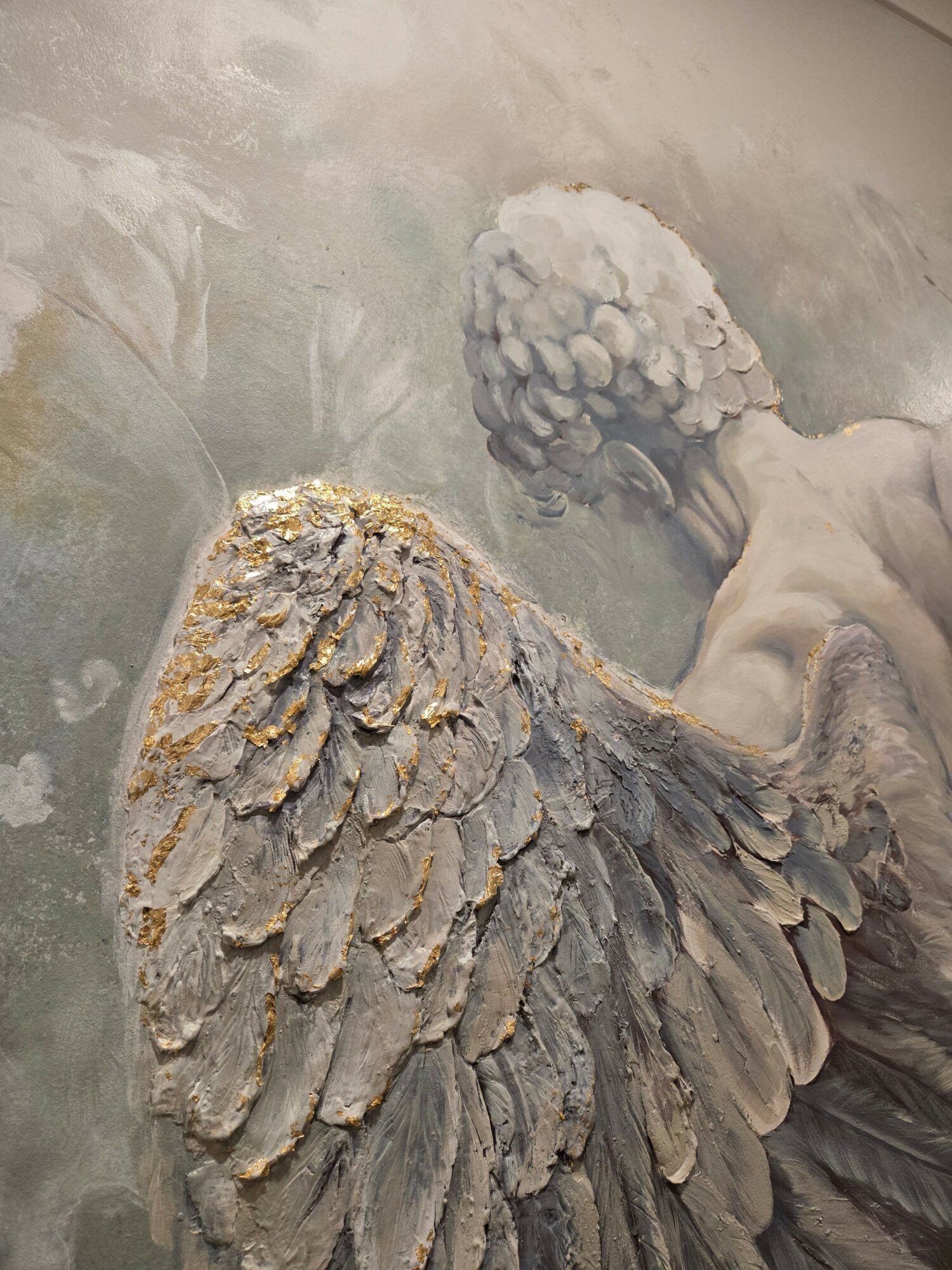 Back of a person with large, detailed feathered wings, facing away, with a textured background.