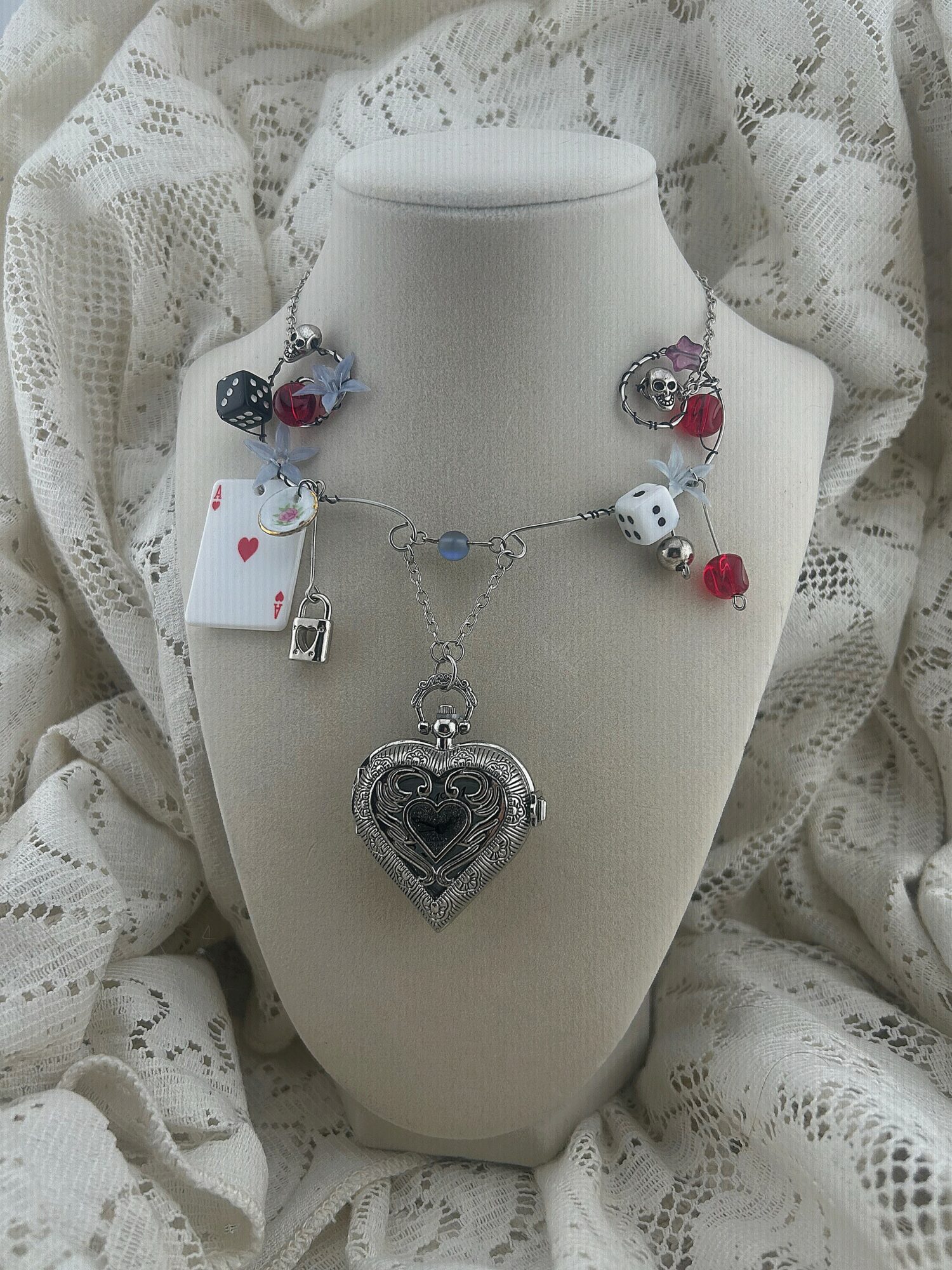 Necklace with a large heart-shaped pendant and various colorful beads displayed on a white bust.