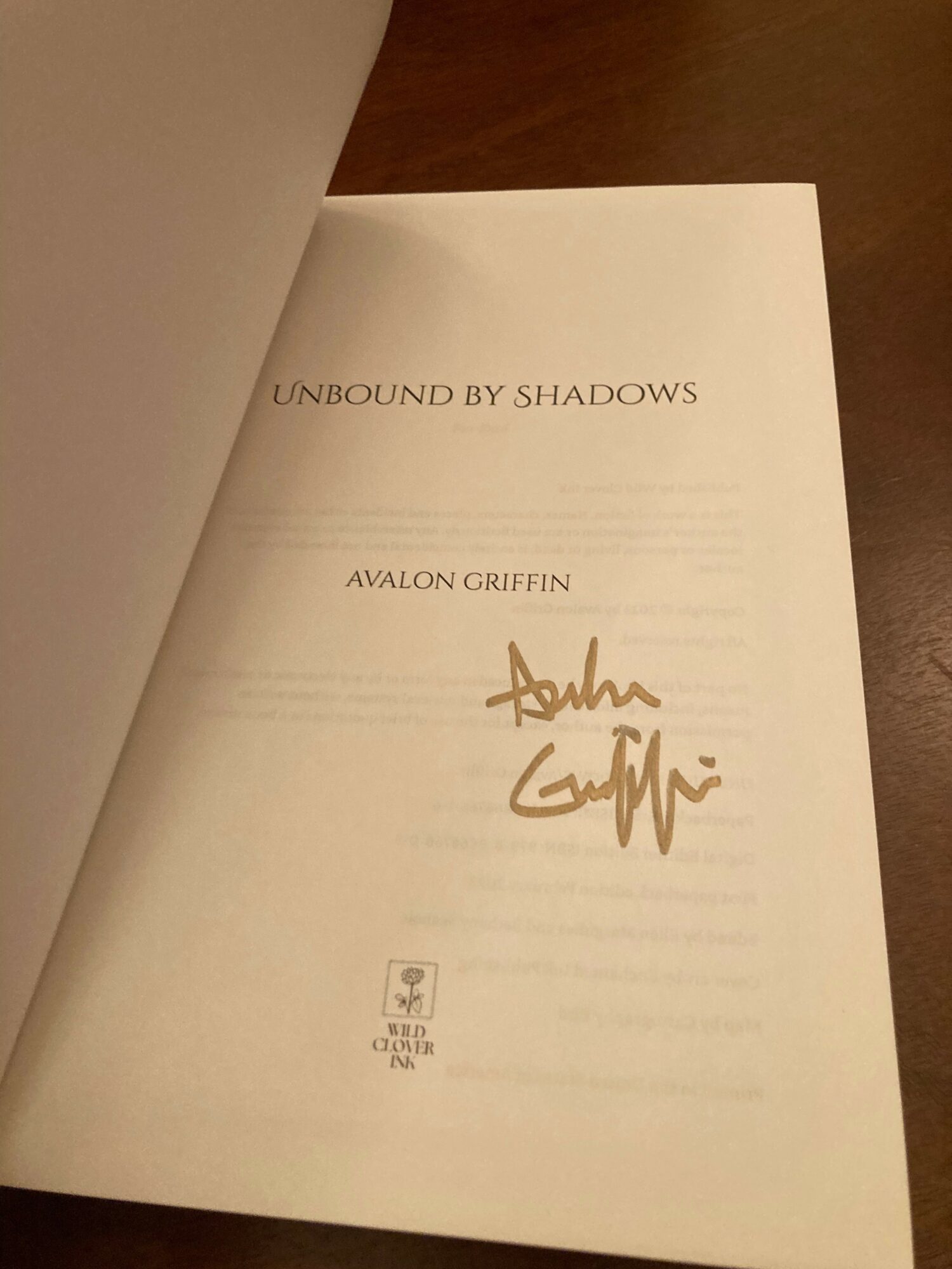 Open book page with title, author's name, and a signature in gold ink.