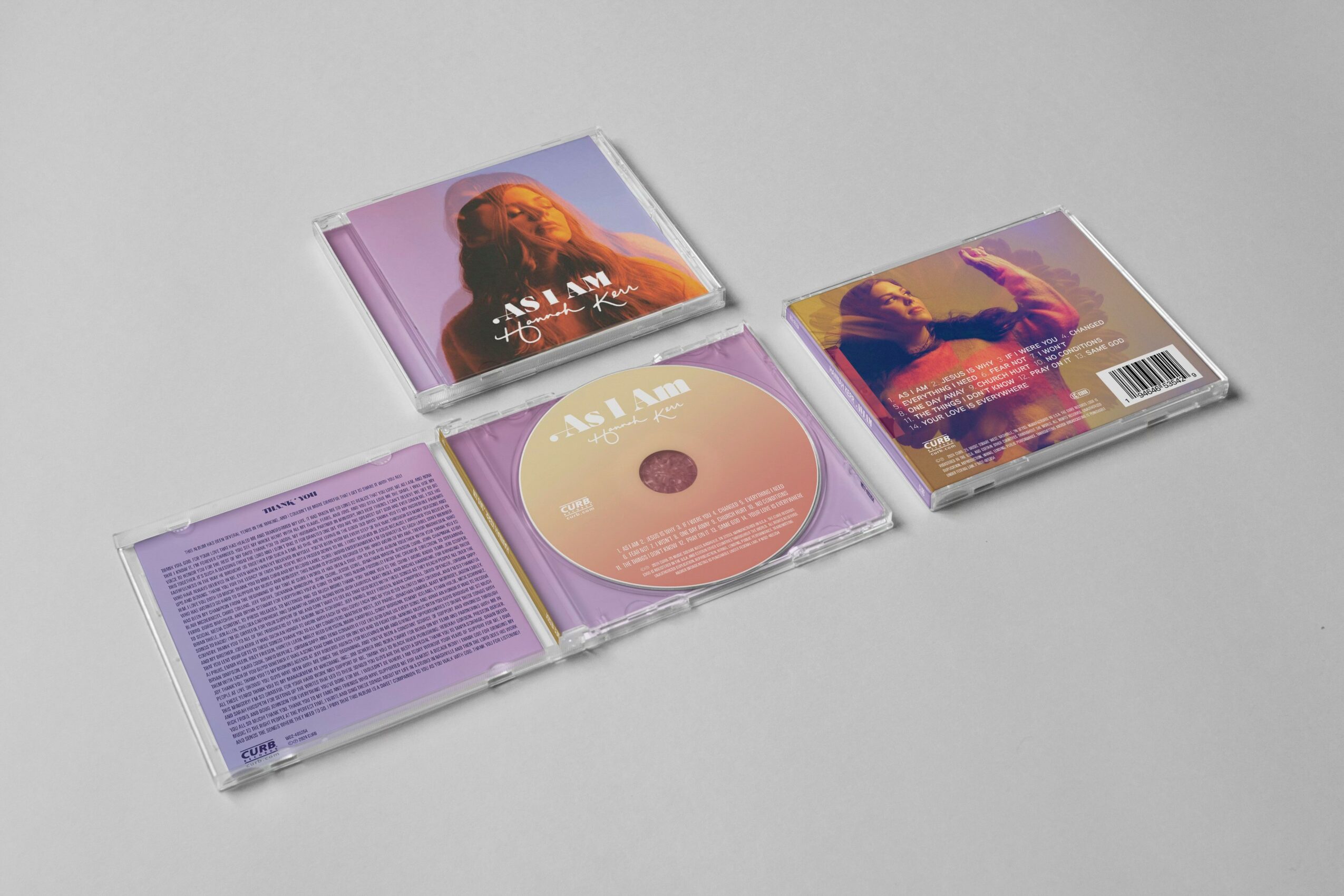 Open CD case with a disc and booklet inside, on a light gray surface.