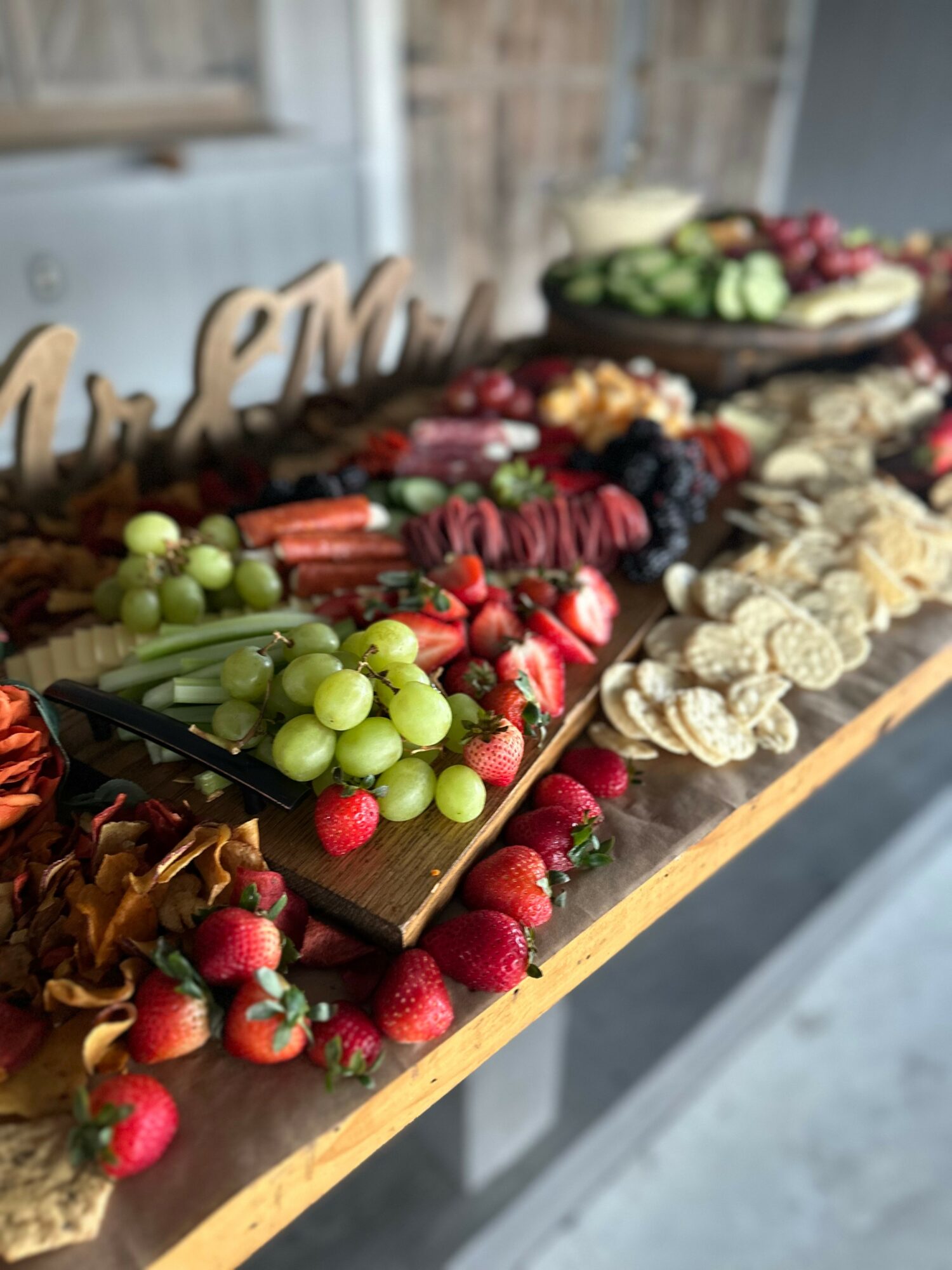 Assorted fruits, vegetables, and snacks arranged on a wooden table with a blurred background.