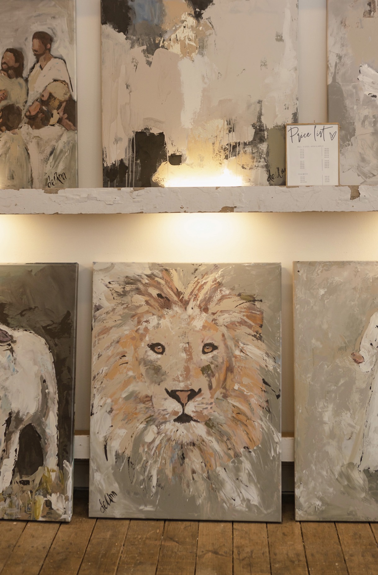 Painting of a lion's face with a detailed mane, set against a neutral background.