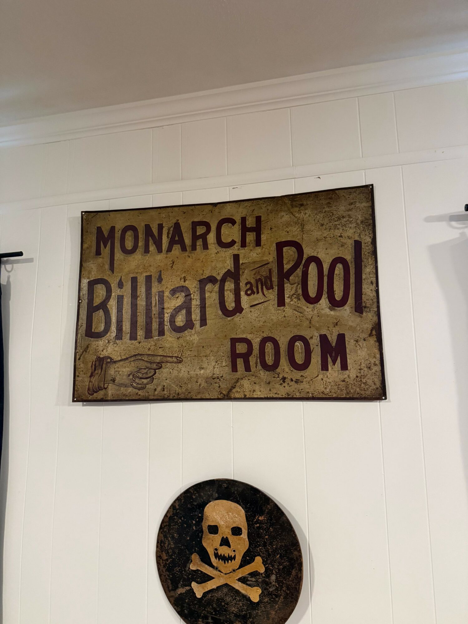 Sign reading 'Monarch March and Ballroom Room' with a decorative background, mounted on a white wall.