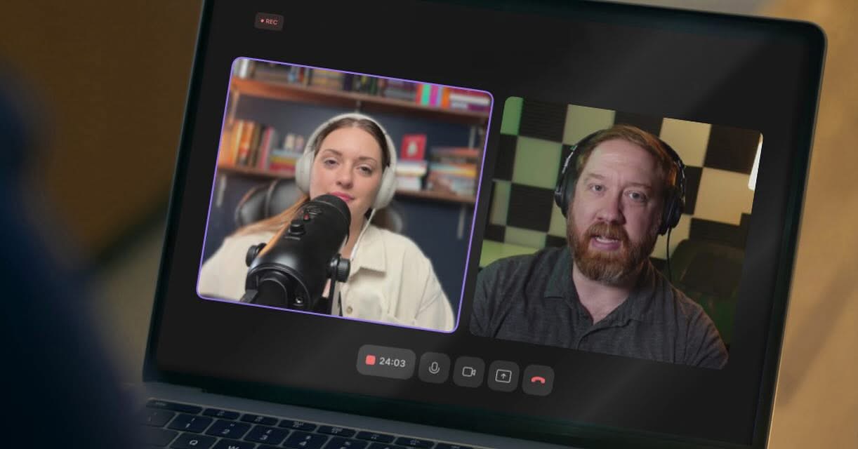 Laptop screen showing two people in a video call, one woman with a microphone and one man with a beard.