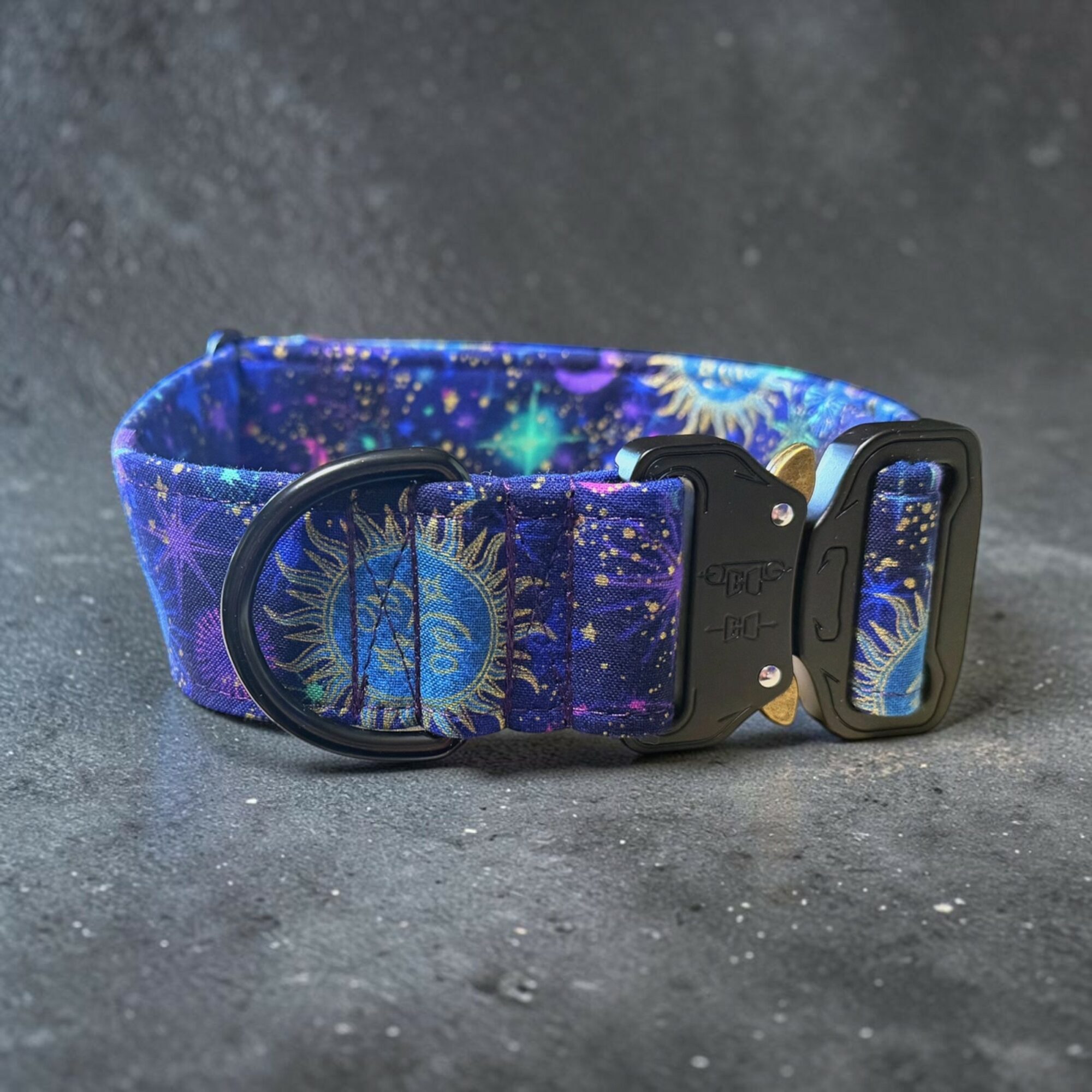 Colorful galaxy-themed dog collar with a black buckle and D-ring, featuring stars and celestial patterns on a dark background.
