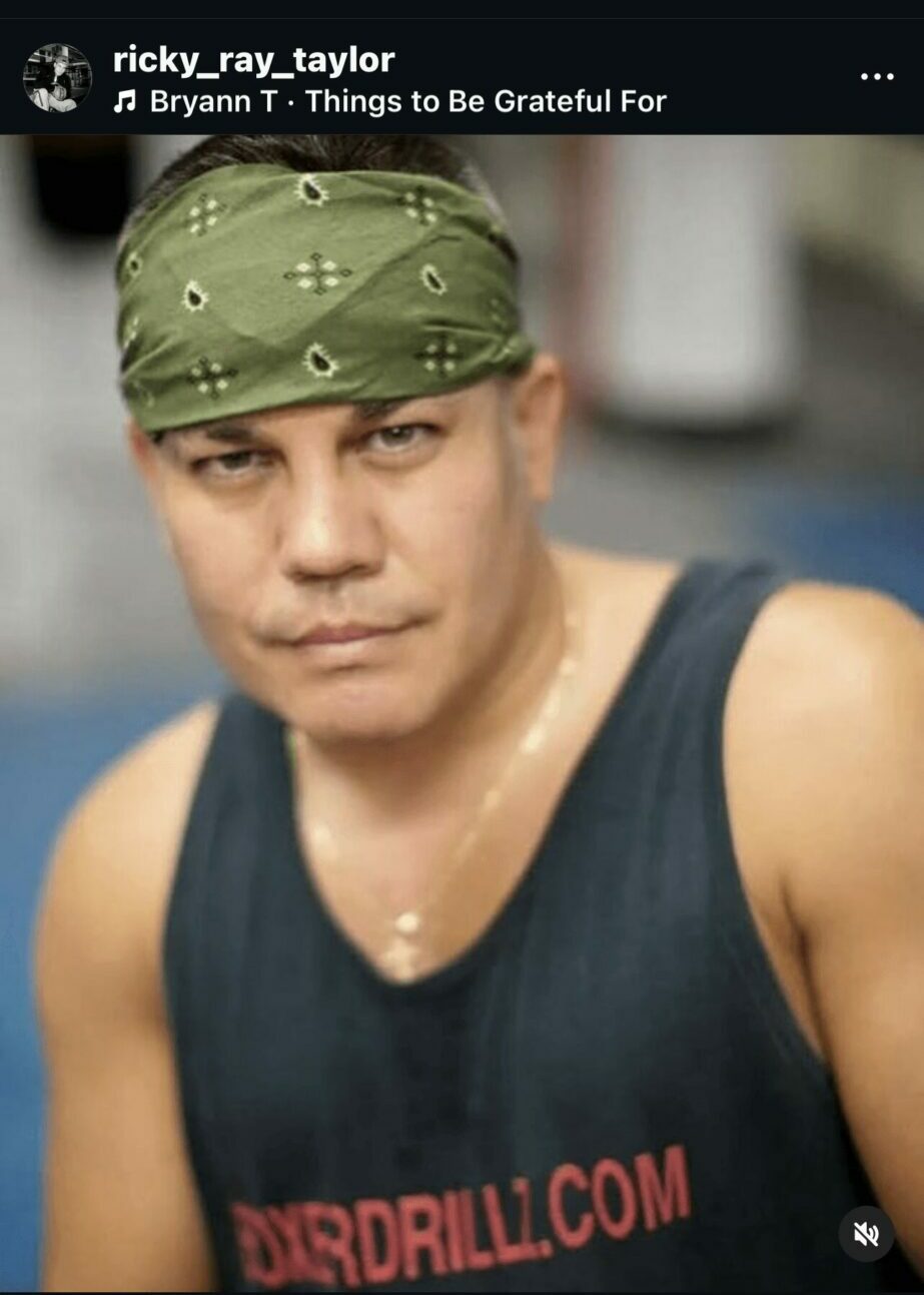 Close-up of a person wearing a green bandana and black tank top, looking at the camera.