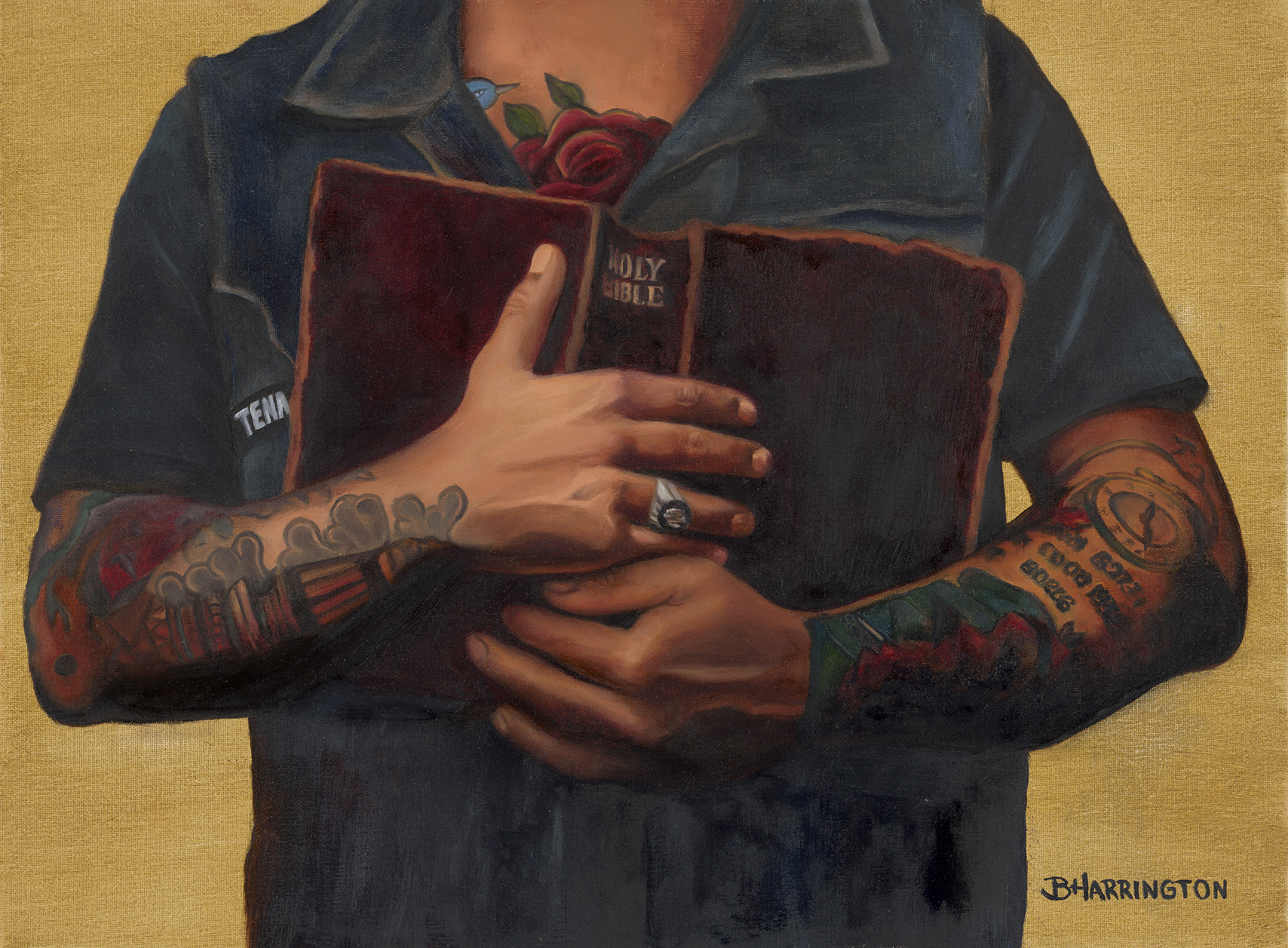 Person holding a book with tattoos on arms, wearing a dark shirt, against a yellow background.