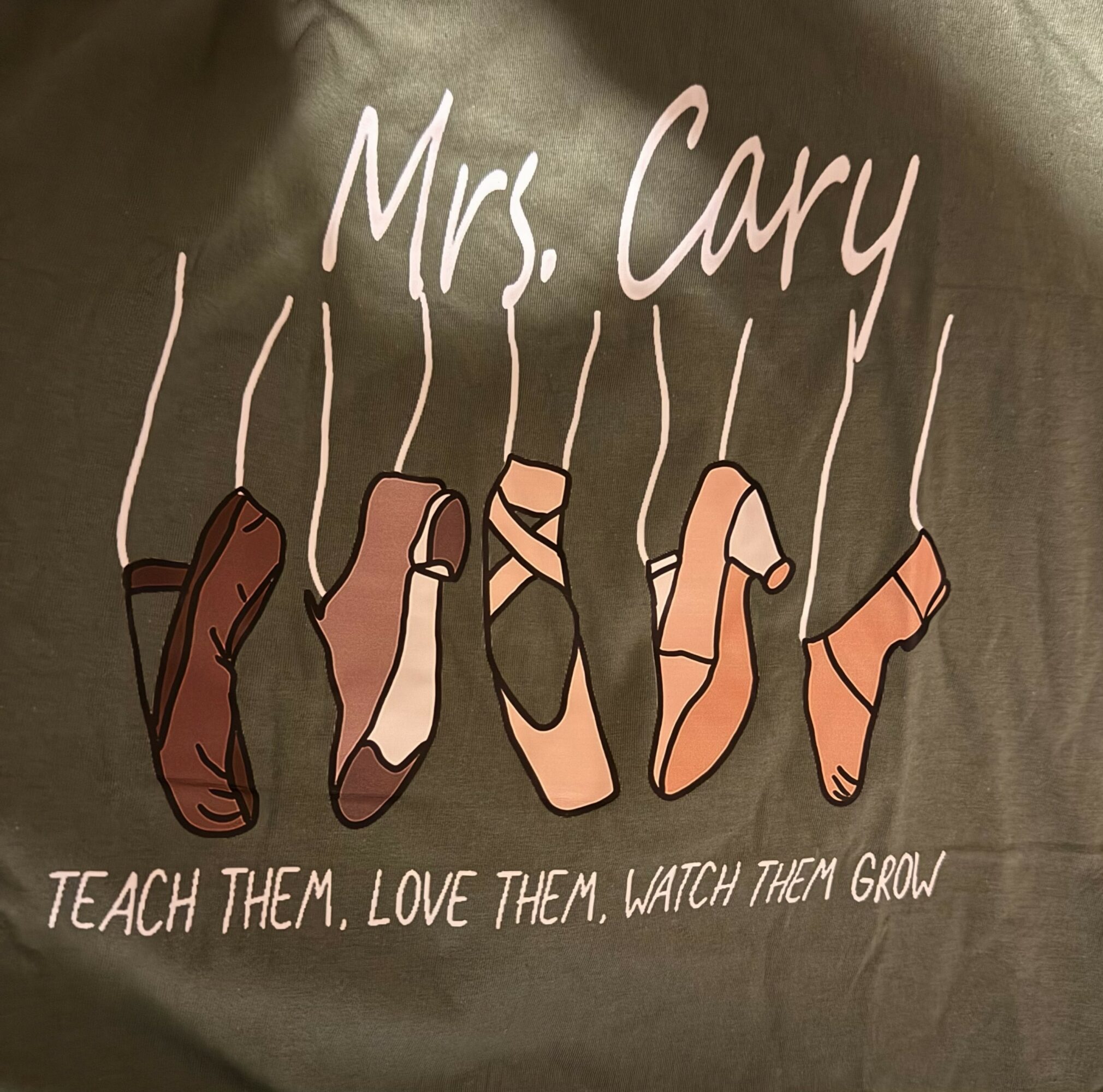 Illustration of five ballet shoes hanging, with text 'Mrs. Cary' and 'Teach them, love them, watch them grow'.