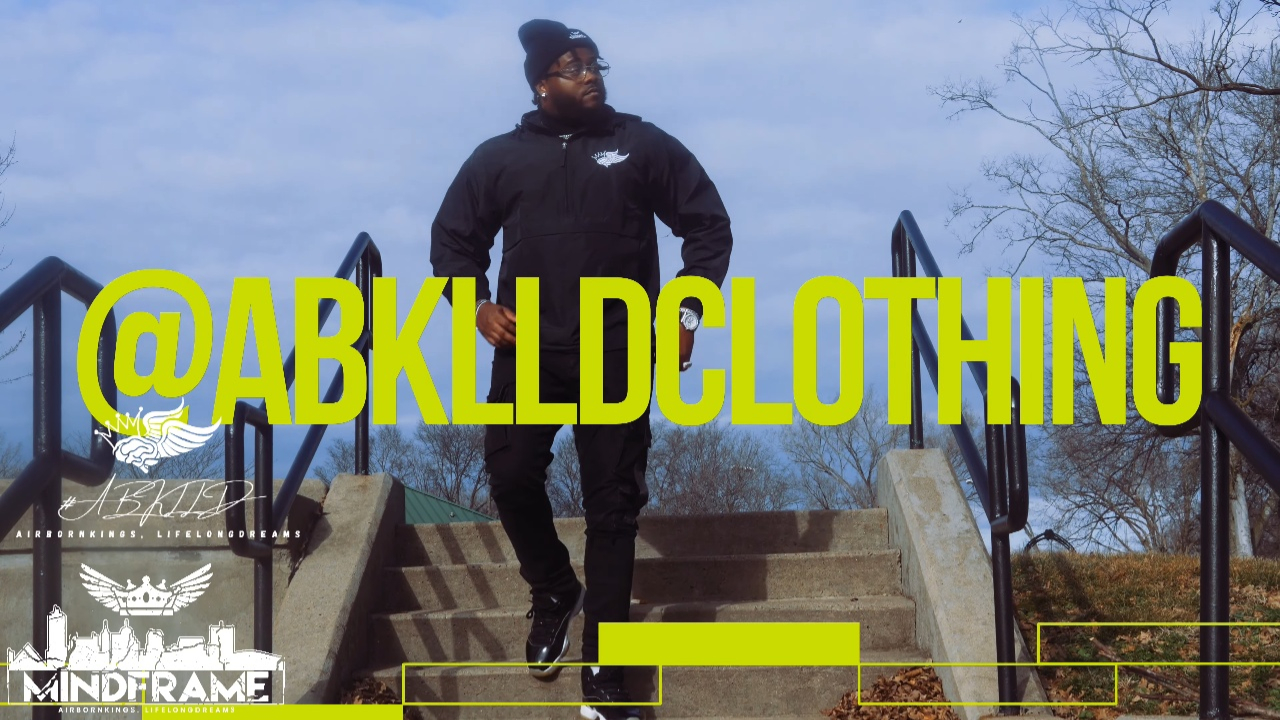 Person standing on stairs outdoors, wearing dark clothing, with trees and sky in background, and text '@ABKLLDCLTHING' overlayed.