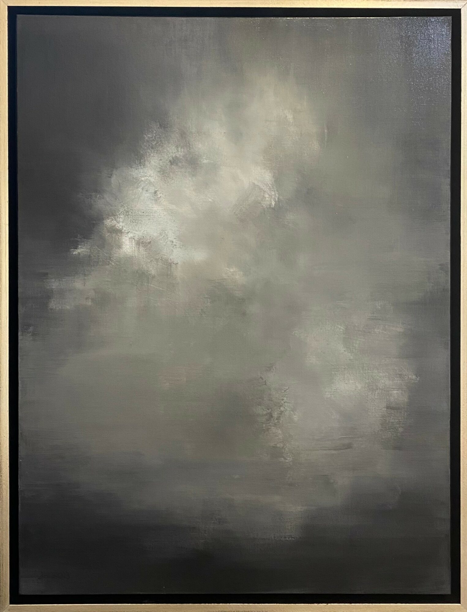 Cloudy sky with dark and light gray clouds, reflecting on a calm body of water, framed in black.