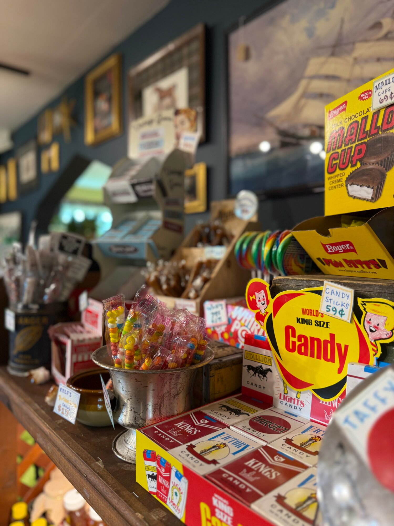 Display of candy and snack items on a store counter with colorful packaging and signs.