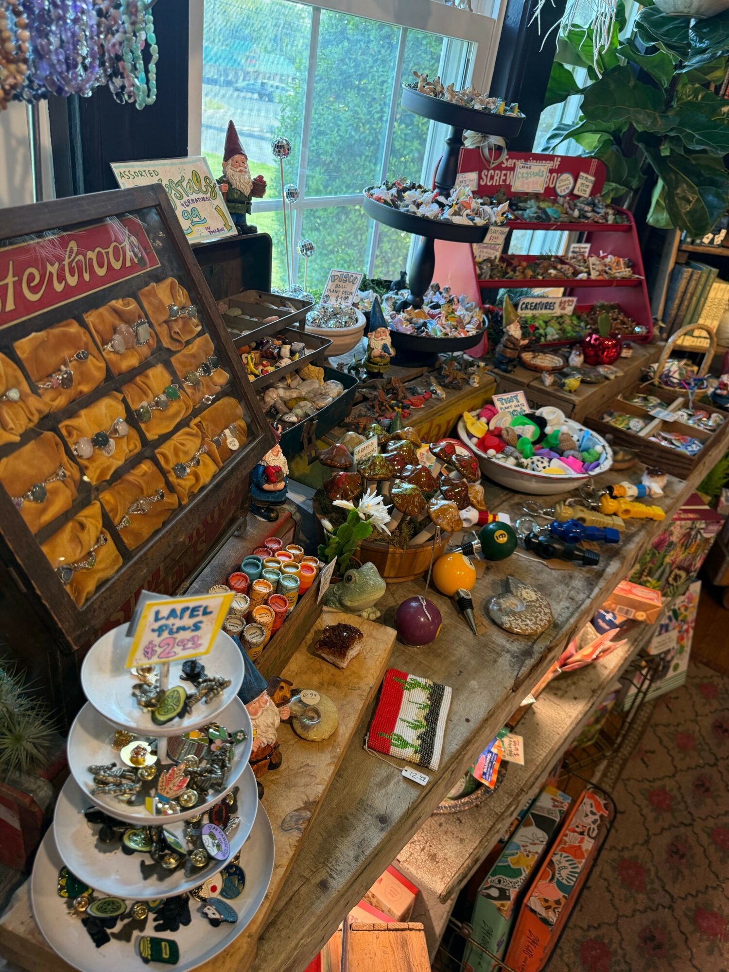 Party table with snacks, drinks, and decorations, viewed from the side with a window in the background.