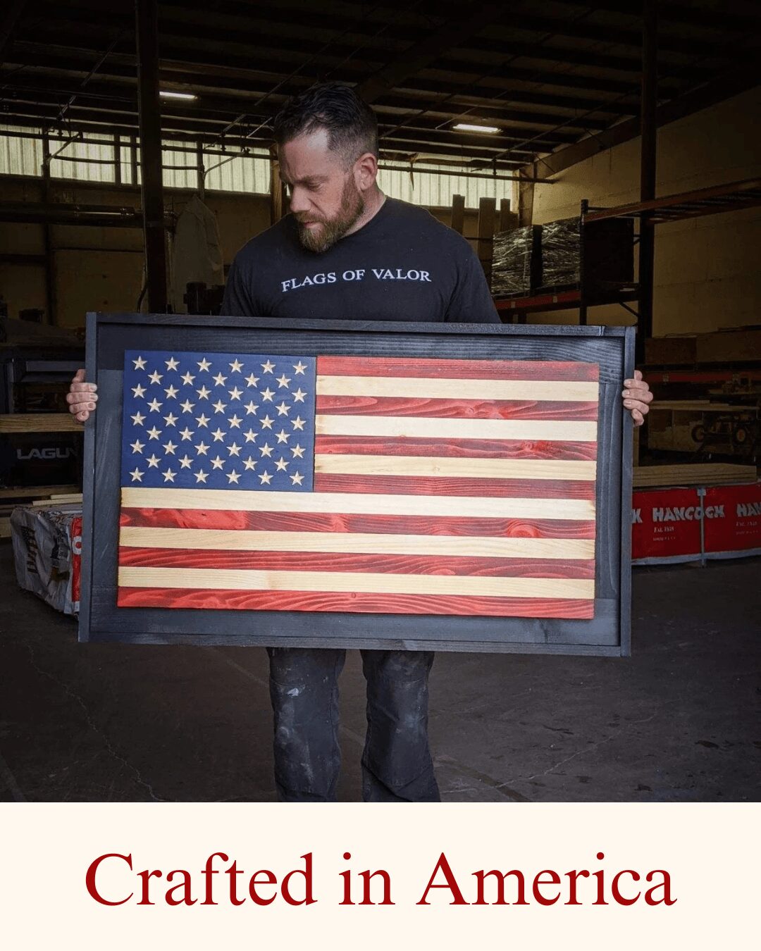 Man holding a framed American flag with stars and stripes, inside a warehouse, with text 'Crafted in America' below.