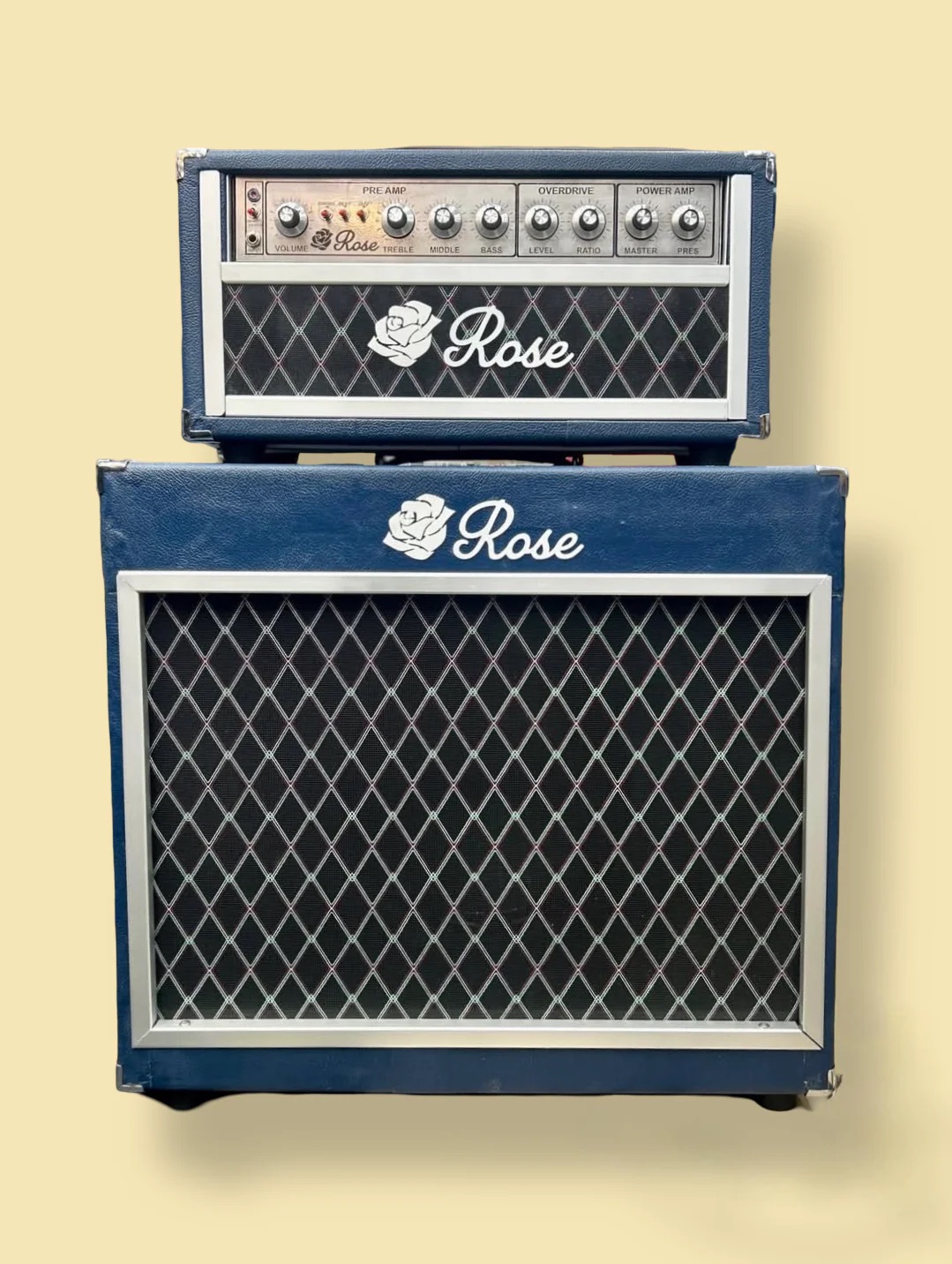 Two guitar amplifiers stacked, one smaller on top of a larger one, both with diamond-patterned grilles and the word 'Rose' on each.