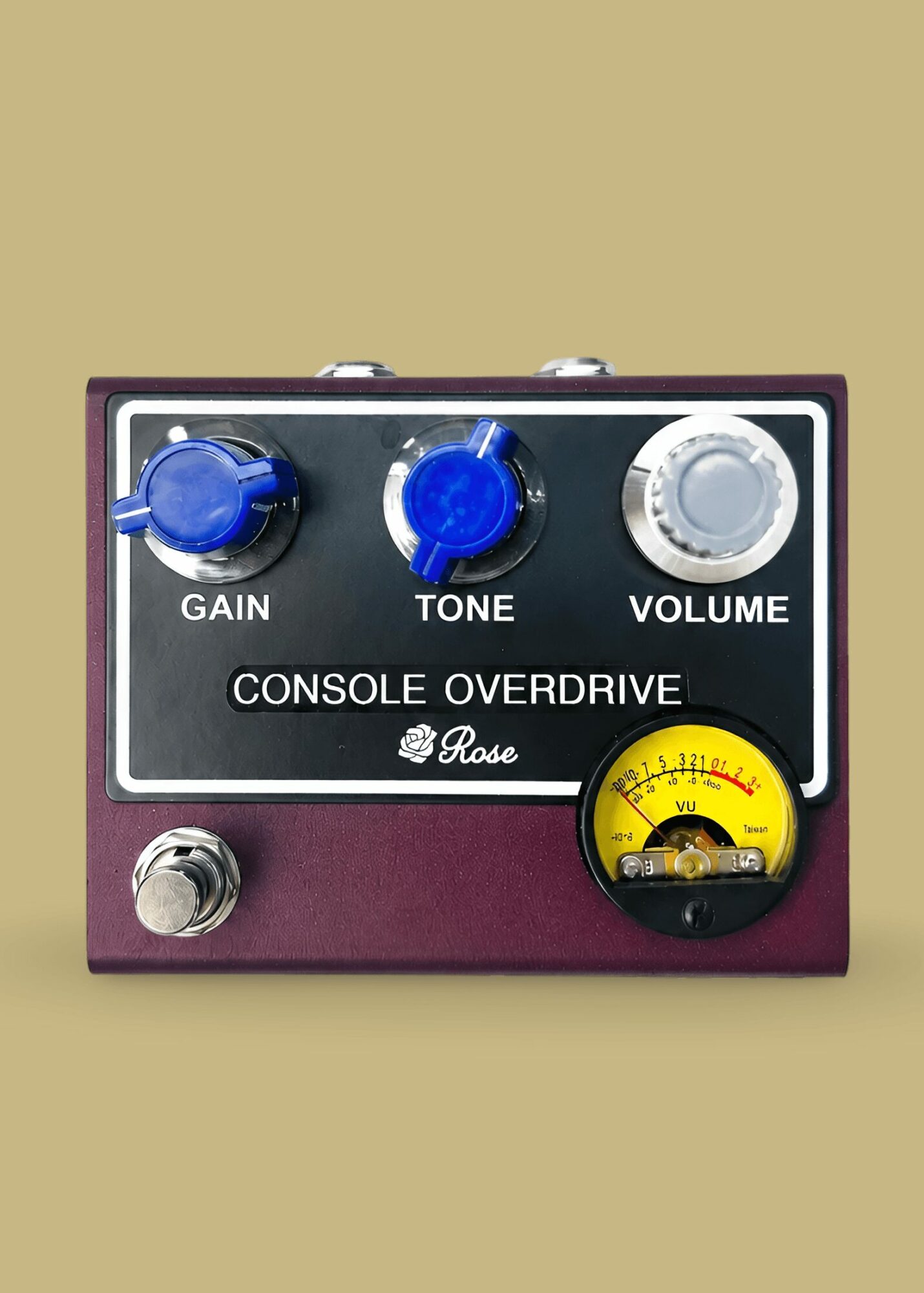Guitar effects pedal with gain, tone, volume knobs, and a yellow meter, on a beige background.