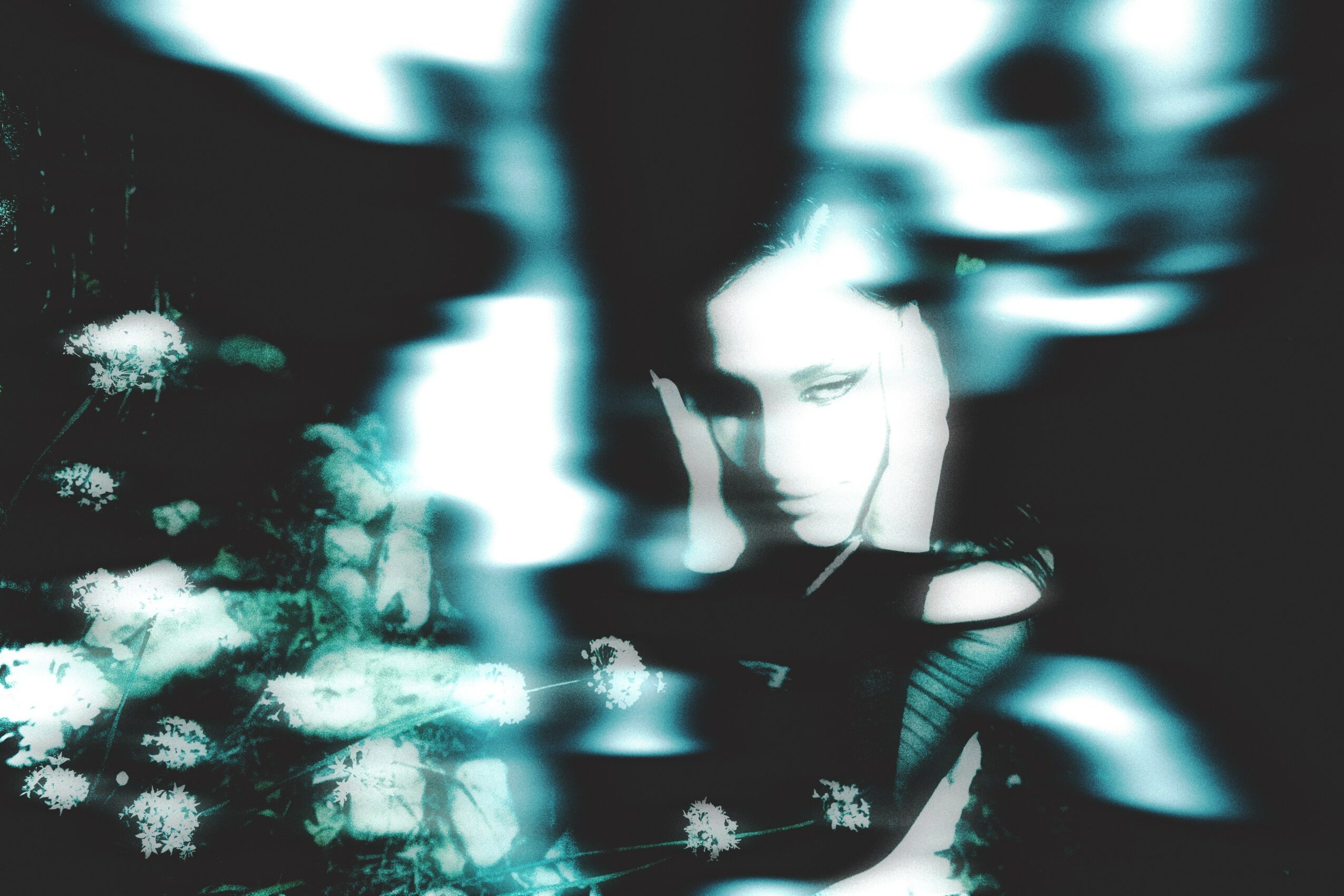 Blurred abstract image with a person's face partially visible, surrounded by light streaks and textures.