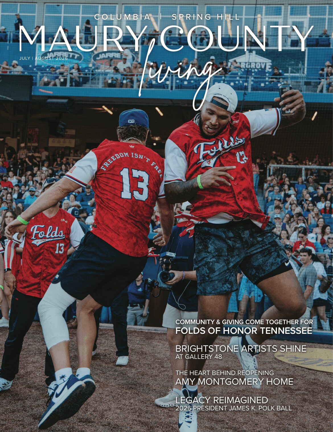 Two baseball players celebrate on the field with a crowd in the background, wearing red and white uniforms. One player is jumping.