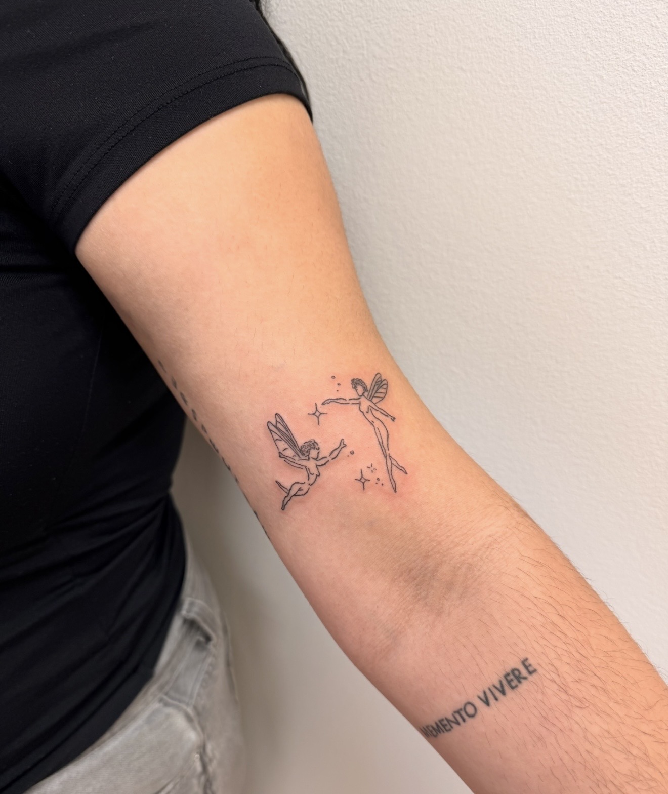 Tattoo of two hummingbirds and a balloon on person's upper arm, with text below reading 'VIBRANDO VIBRE'. Alt text word count: 15.