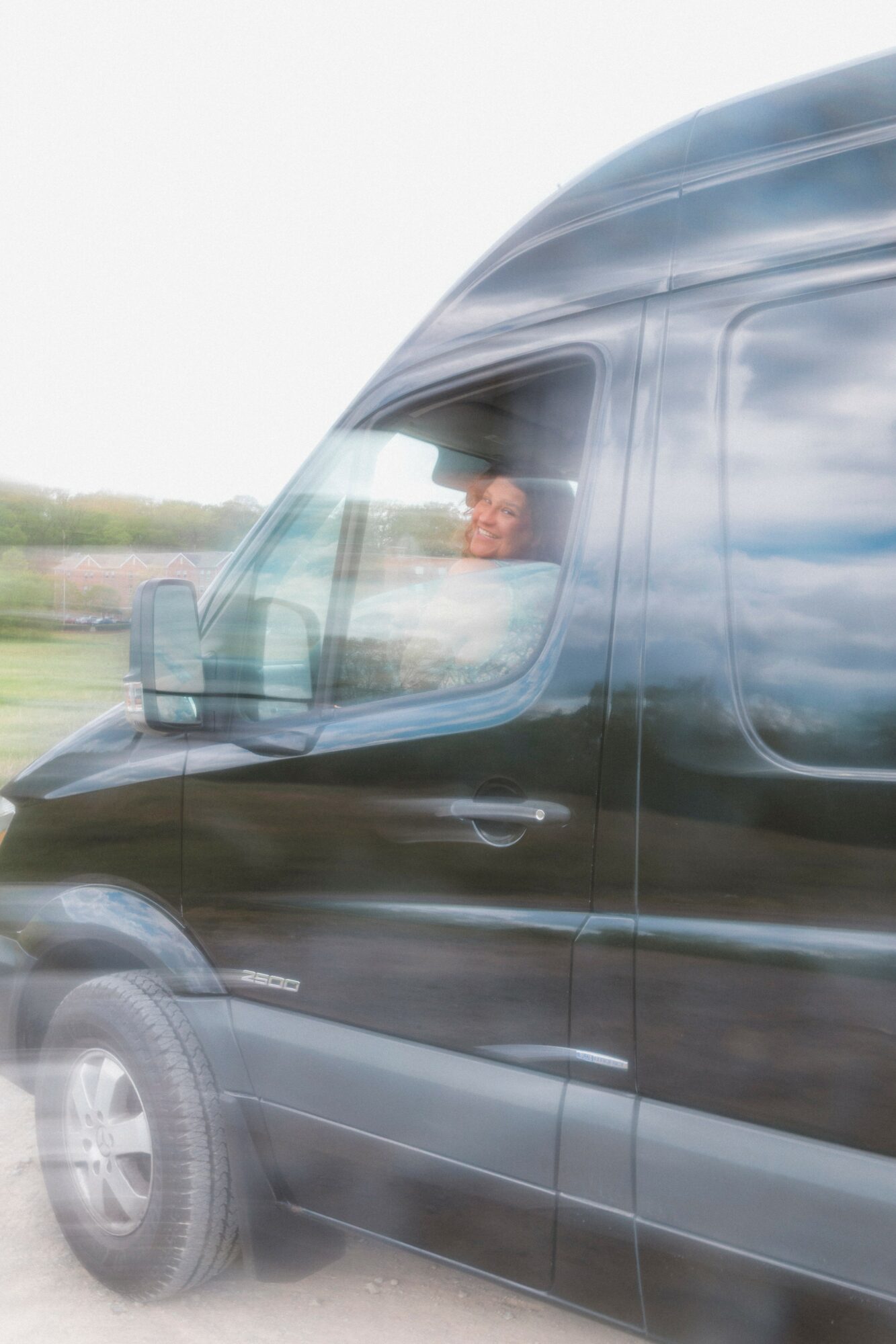 Driver visible through the truck's front window, with a blurred background indicating motion.