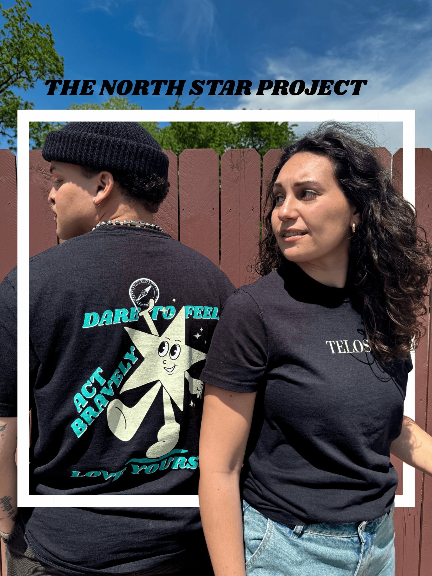 Two people outdoors, one wearing a black beanie and a black T-shirt with a star and text, the other with curly hair and a black T-shirt, standing in front of a wooden fence.
