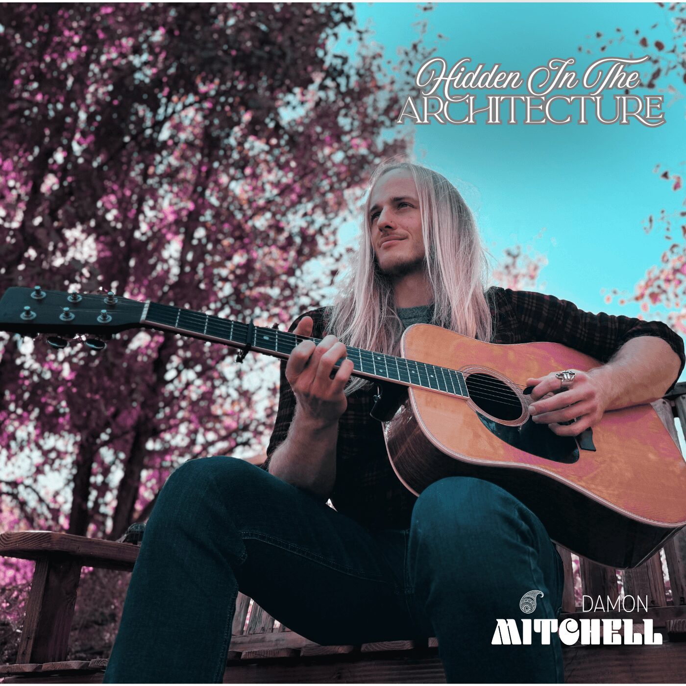 Person with long hair playing guitar outdoors with pink flowering trees in background, blue sky, and text overlay.