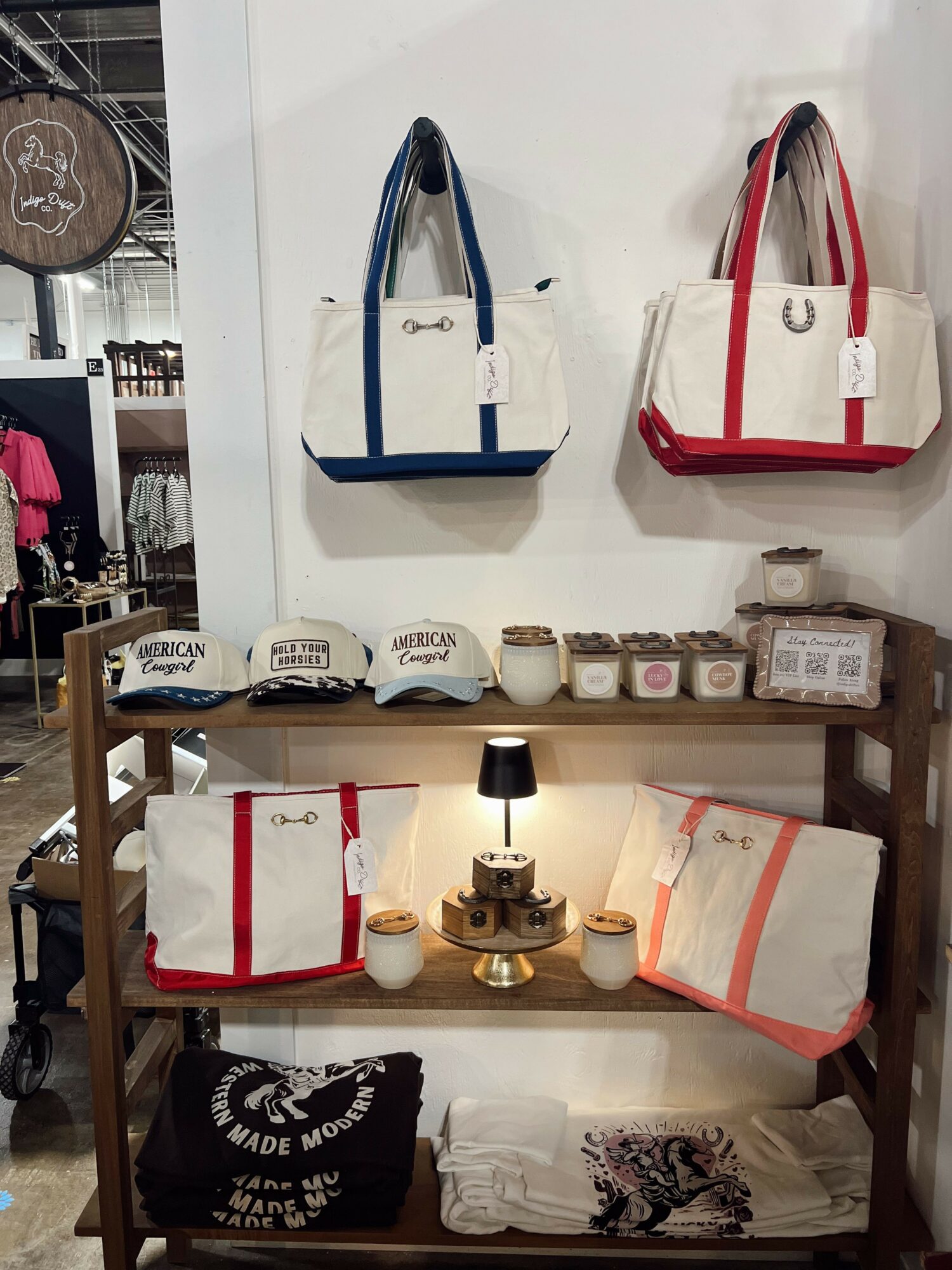 Display of bags, jars, and cups on shelves with a wooden frame, some bags hanging on the wall, and a black bag with white text.