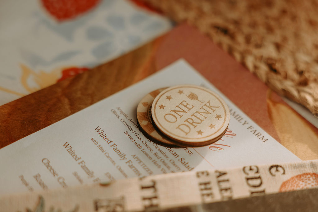 Close-up of two round buttons, one with the text 'ONE AND DONE', resting on a paper with text, on a table.