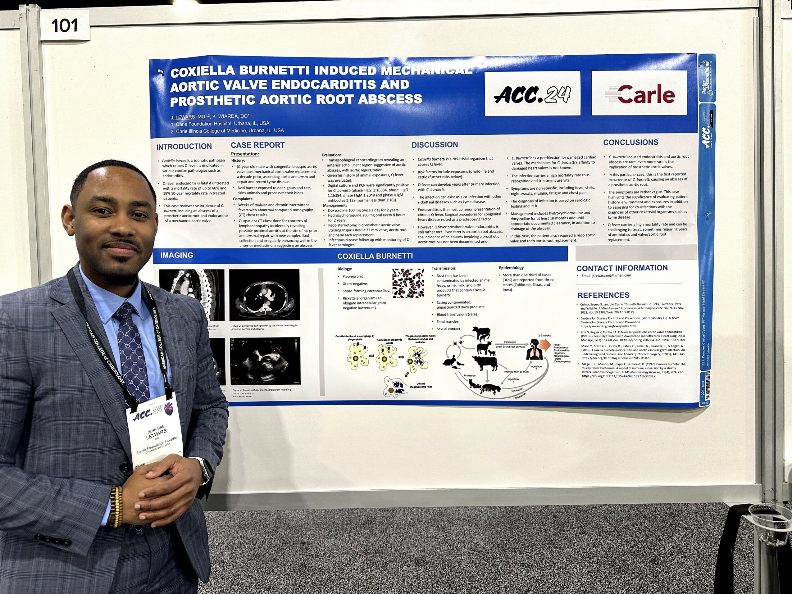 Man in suit standing in front of a scientific research poster at a conference.