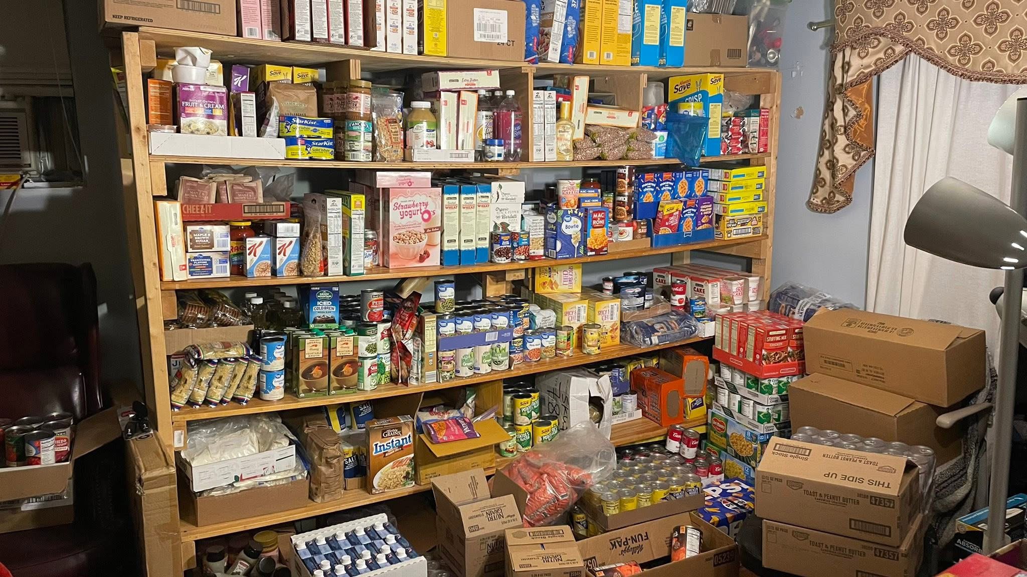 Bookshelves filled with various food and household items, with boxes and supplies on the floor nearby.