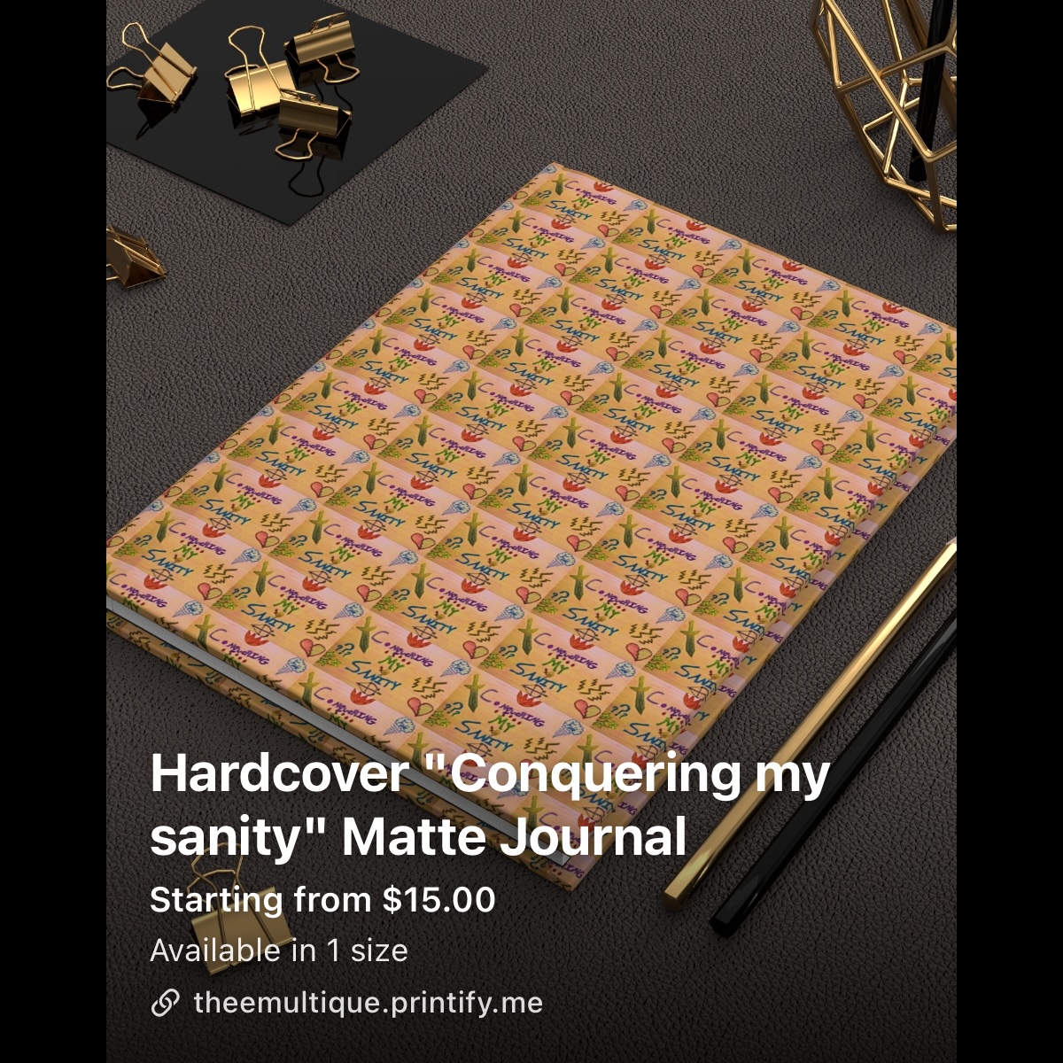Matte journal with colorful floral cover on a dark surface, with black and gold objects nearby.