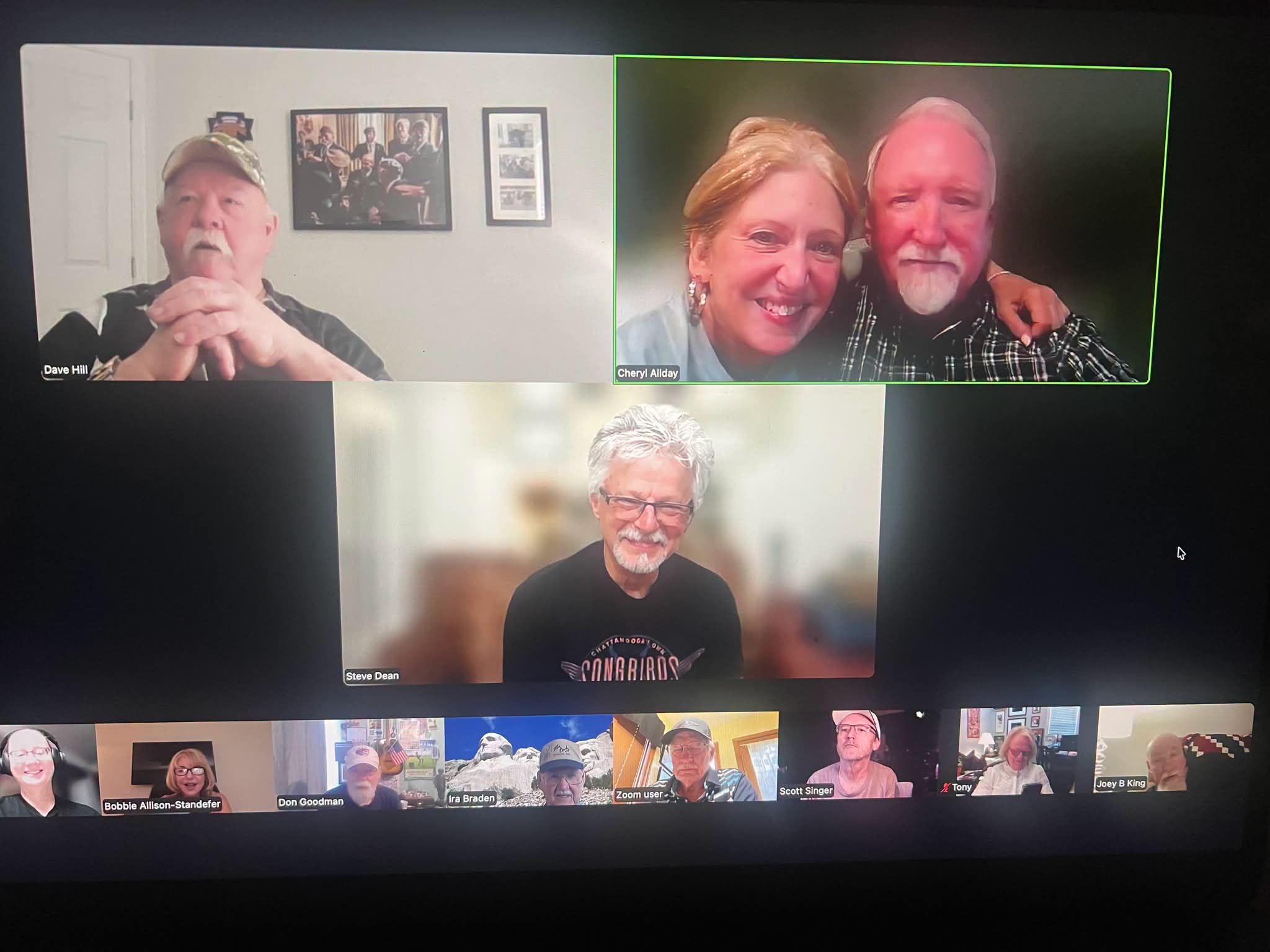 Three people in a video call, two smiling together and one smiling alone, with a blurred background.