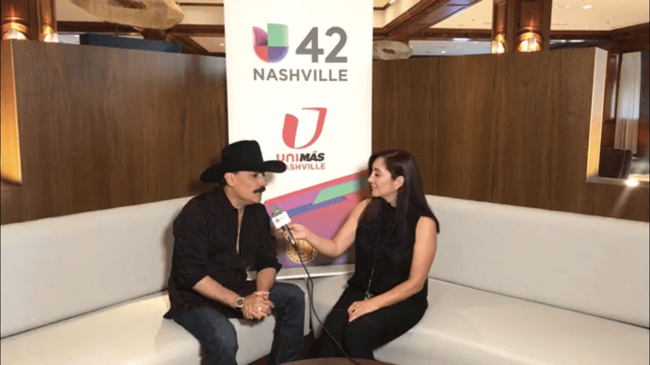 Two women sit on a white couch during an interview, with a Nashville 42 sign in the background.