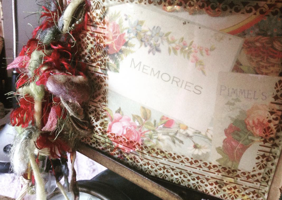 Decorative box with floral design and the word 'MEMORIES' inside, surrounded by red and pink flowers and ribbons.