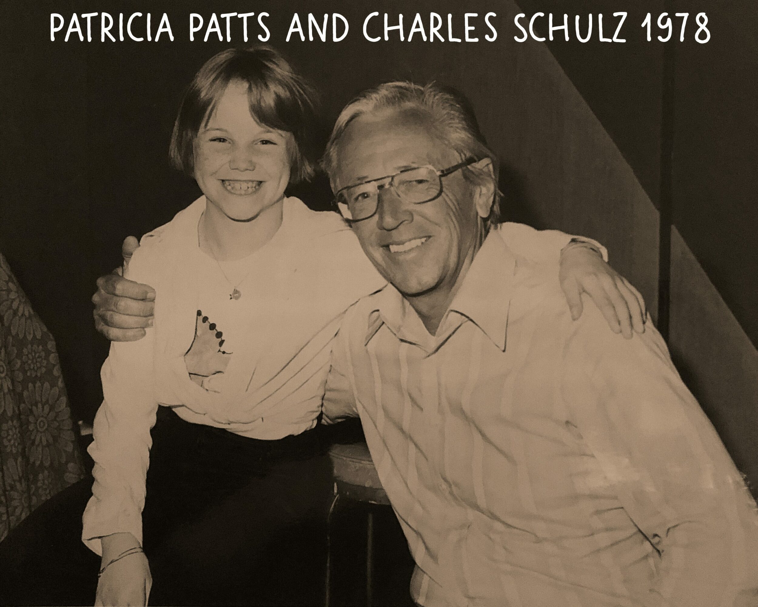 Young girl and older man smiling, with the girl hugging the man, text at top reads 'Patricia Patts and Charles Schulz 1978'.