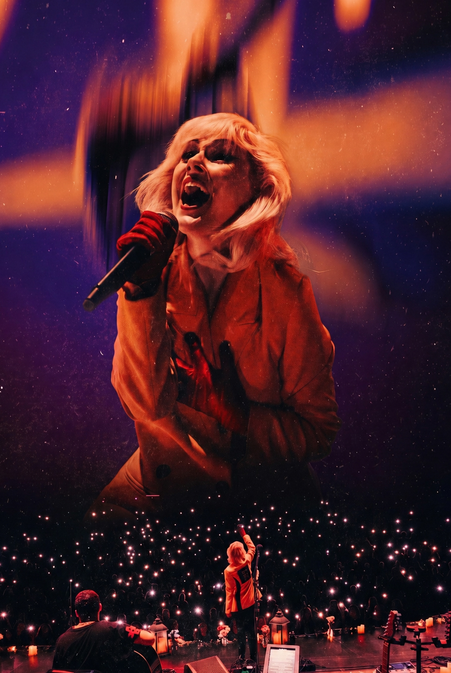 Performer singing passionately on stage with a microphone, surrounded by a starry background and audience lights.