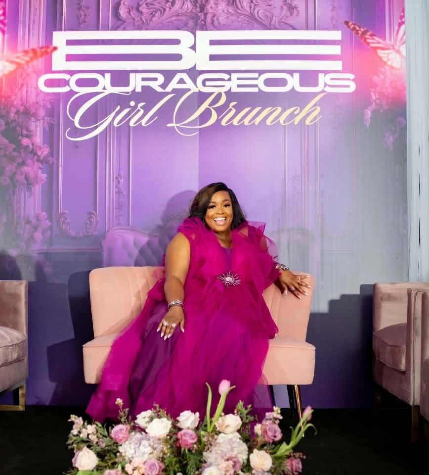 Woman in pink dress sitting on a beige sofa, floral arrangement in front, purple background with event text.