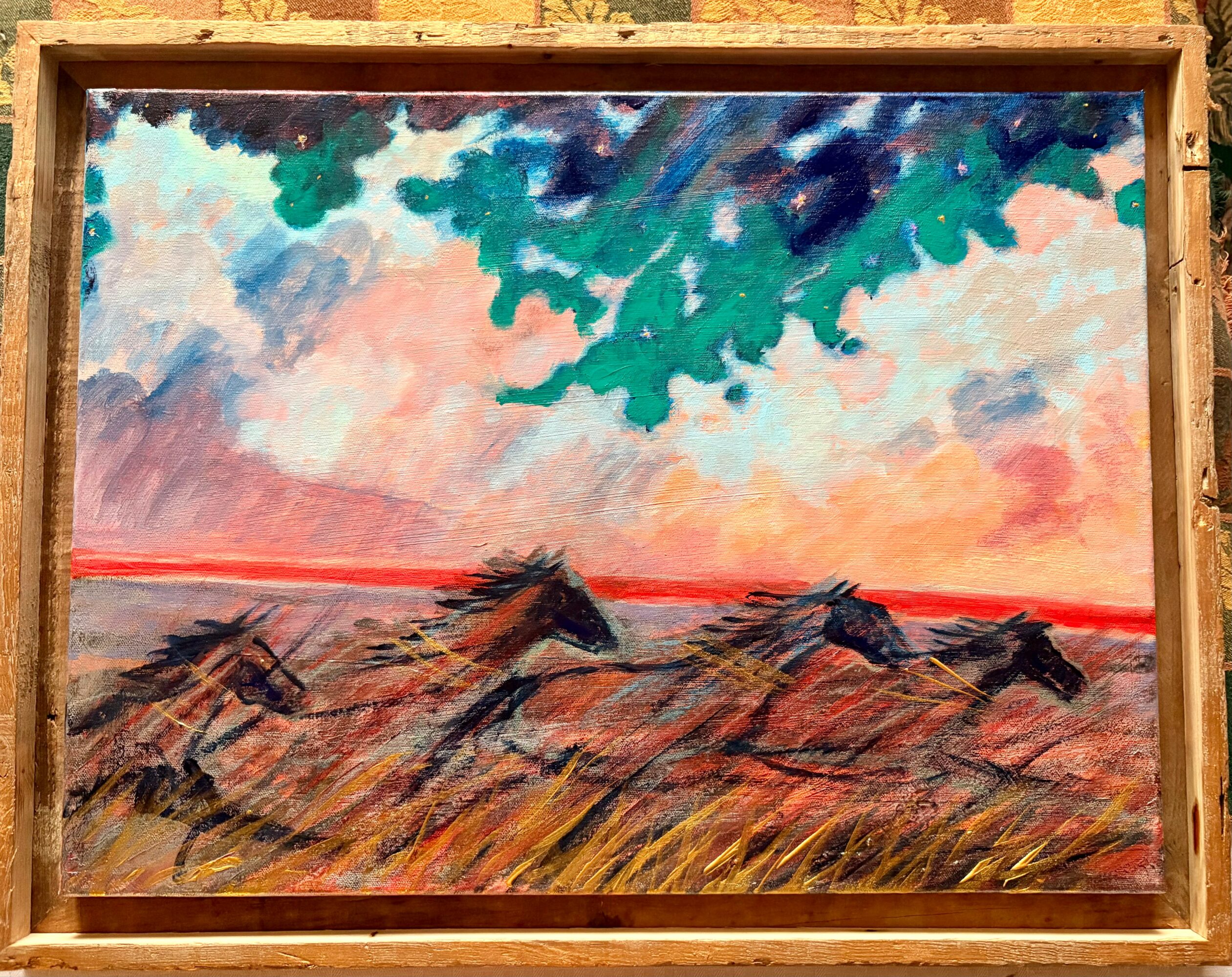 Landscape painting of horses running on a field with a colorful sky and tree branches above, framed in wood.