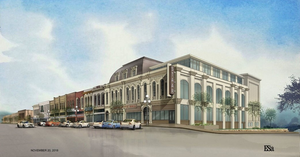 A row of multi-story buildings with large windows and decorative architecture, parked cars in front, and a cloudy sky above.