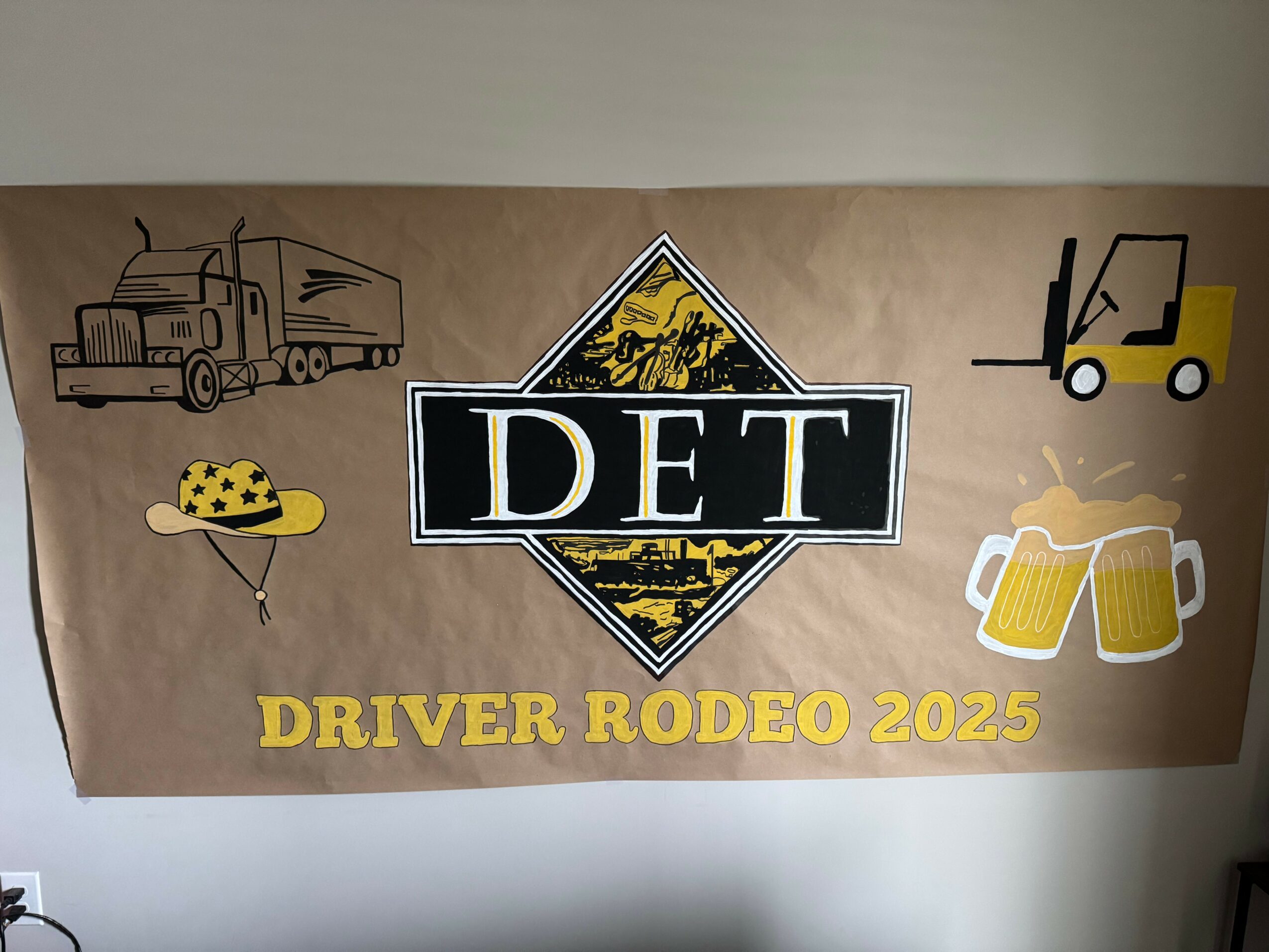 Banner with illustrations of a truck, a forklift, and two beer mugs, with text 'DET' and 'DRIVER RODEO 2025'.