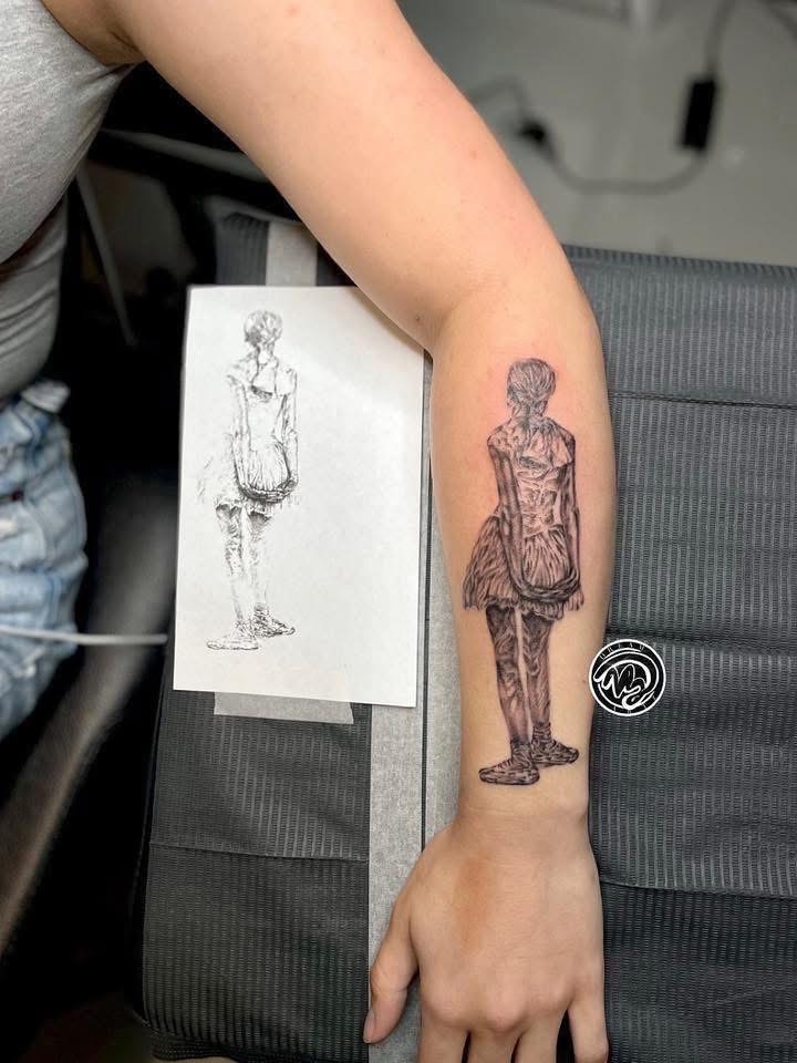 Person's arm with a tattoo of a girl in a dress, with a sketch of the same design beside it.