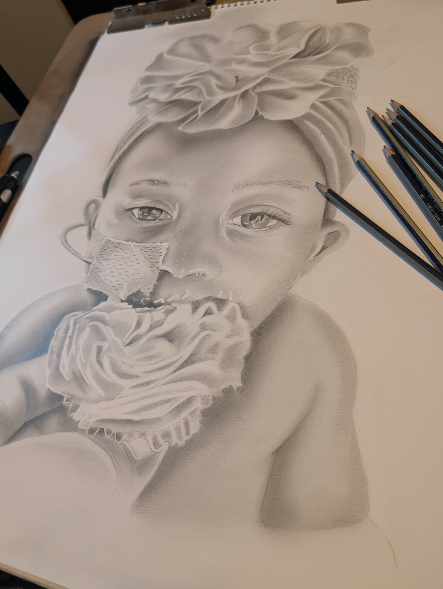 Detailed pencil drawing of a child with a large flower headpiece, holding a cupcake, with colored pencils nearby.