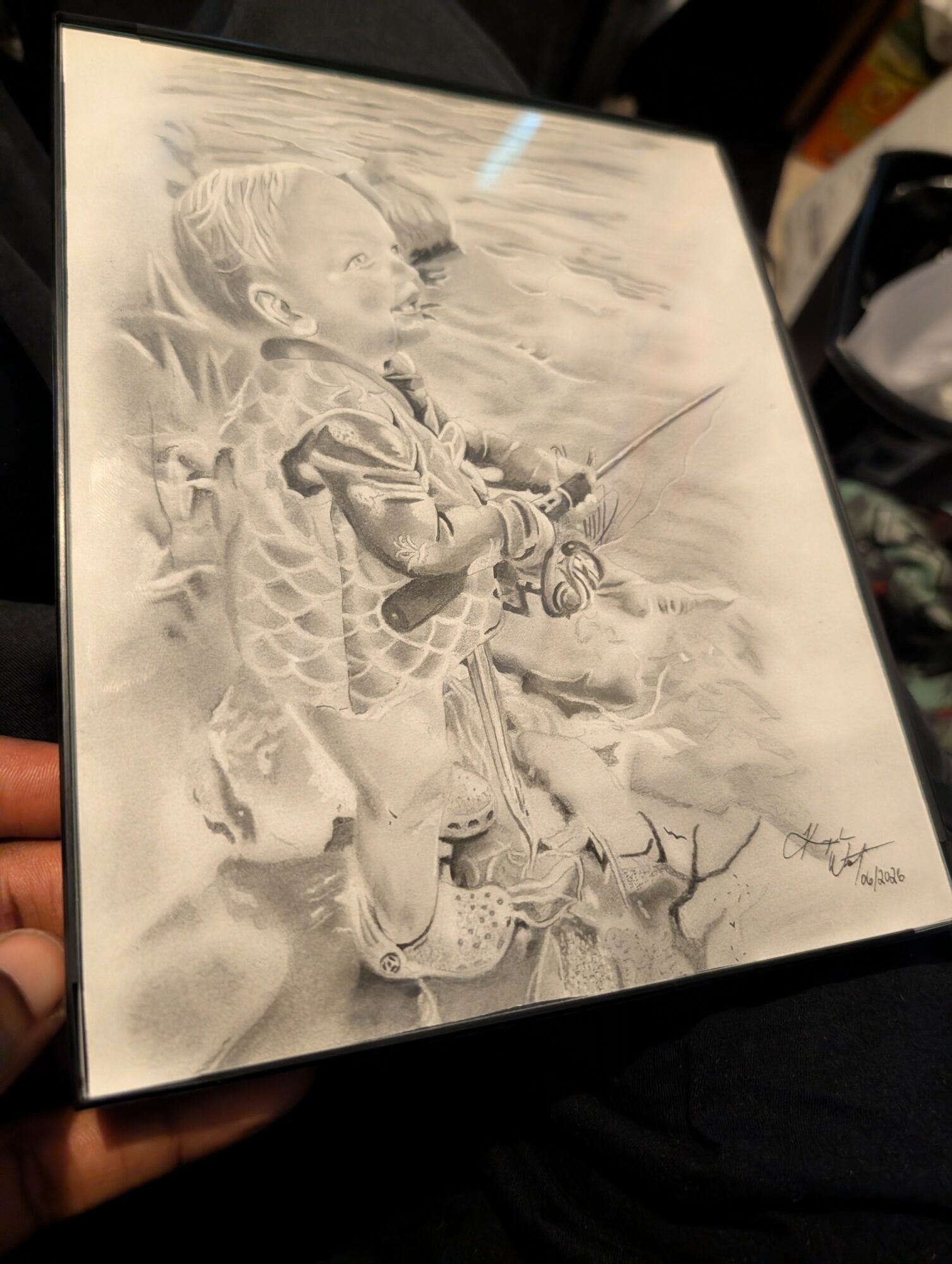 A detailed pencil drawing of a young boy fishing, standing on rocks with water in the background.