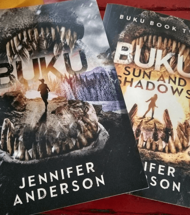 Two books titled 'Buku' by Jennifer Anderson with mountain and person silhouettes, featuring large teeth framing the covers.