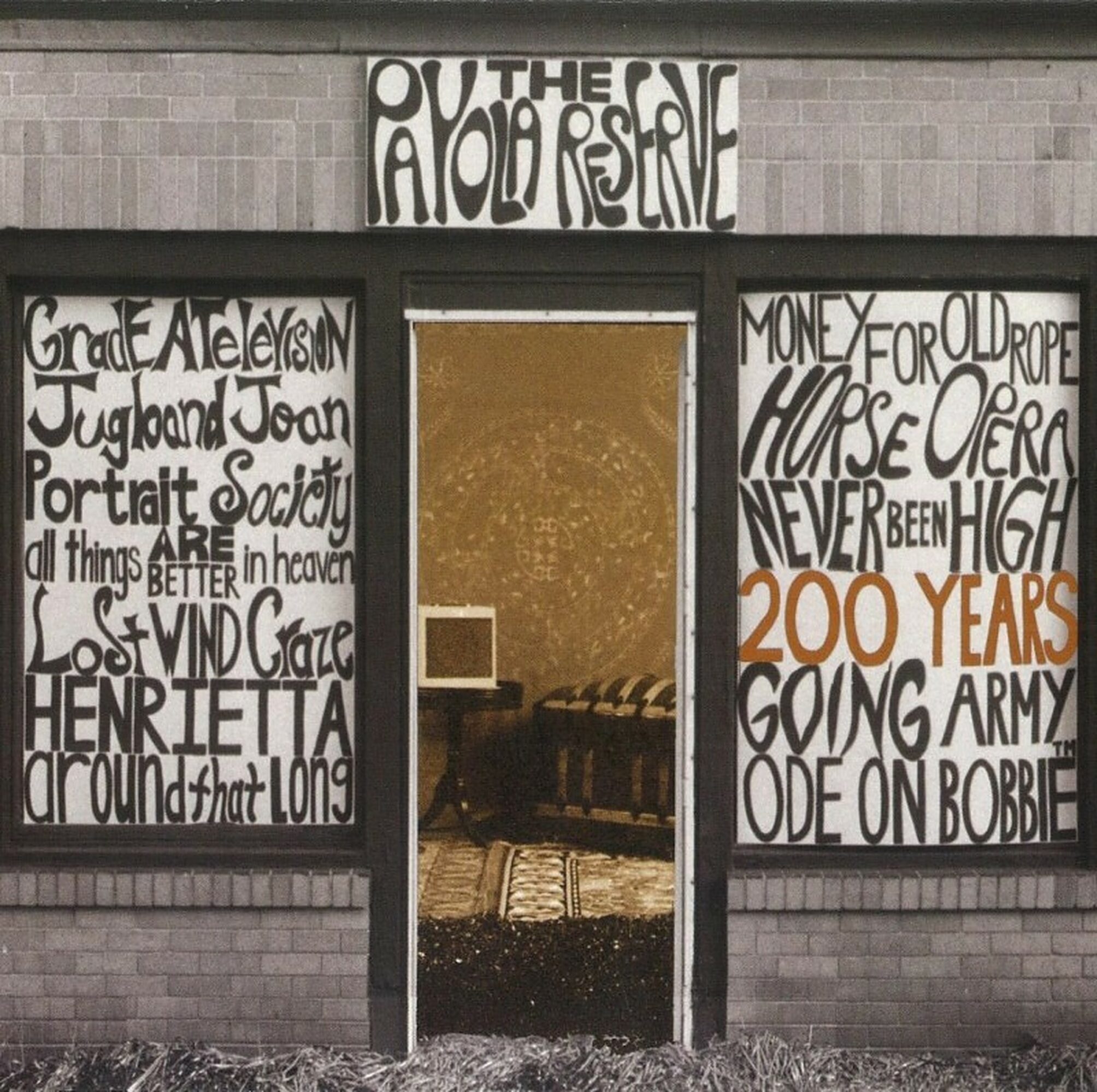 Open doorway with posters on sides and a sign above, revealing a room with chairs and a rug inside.