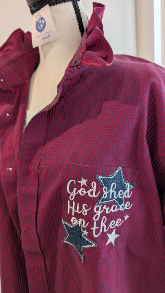 Close-up of a maroon jacket with embroidered text and star designs on the chest.