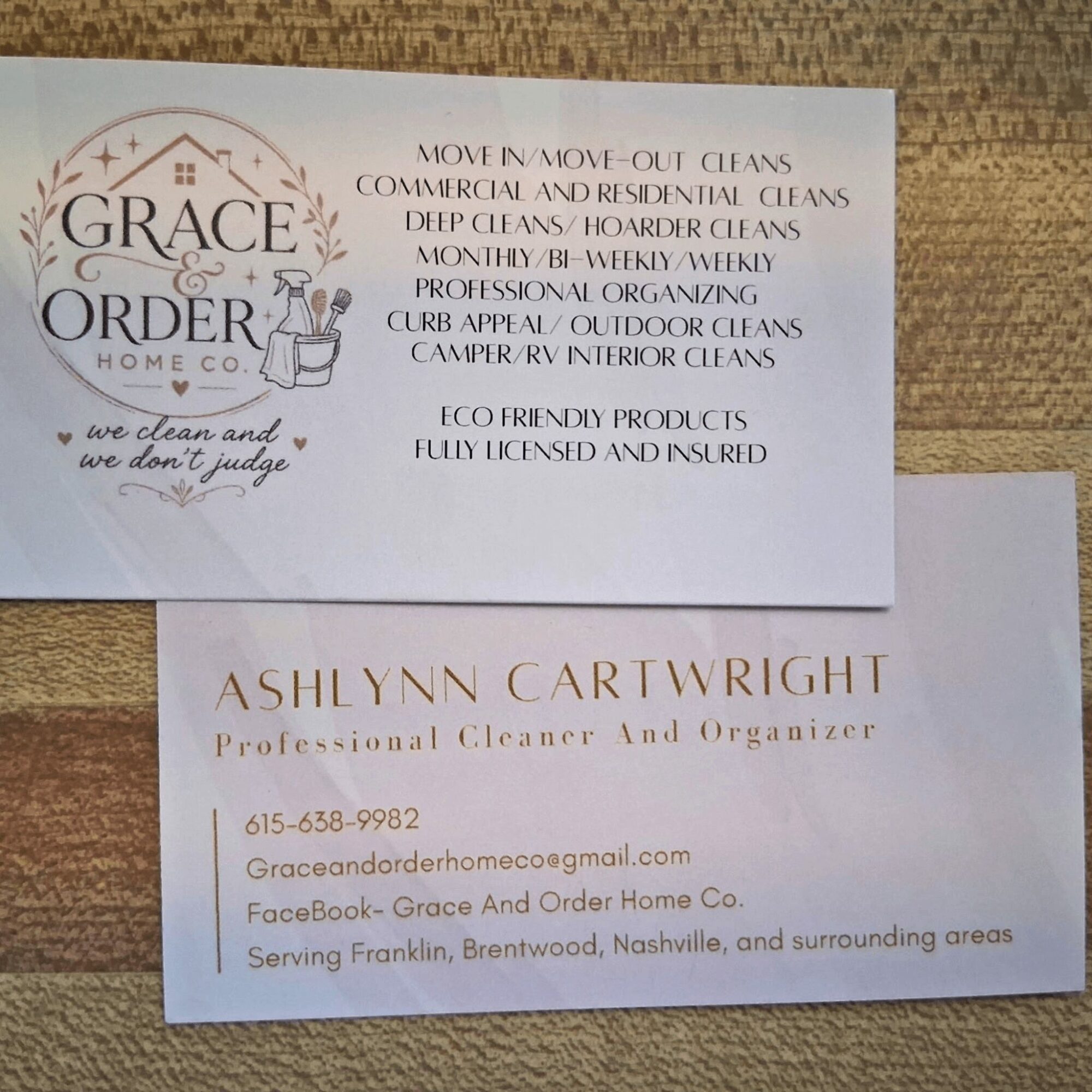 Business card for Grace and Order Home Co. with services listed and contact information, on a wooden surface.