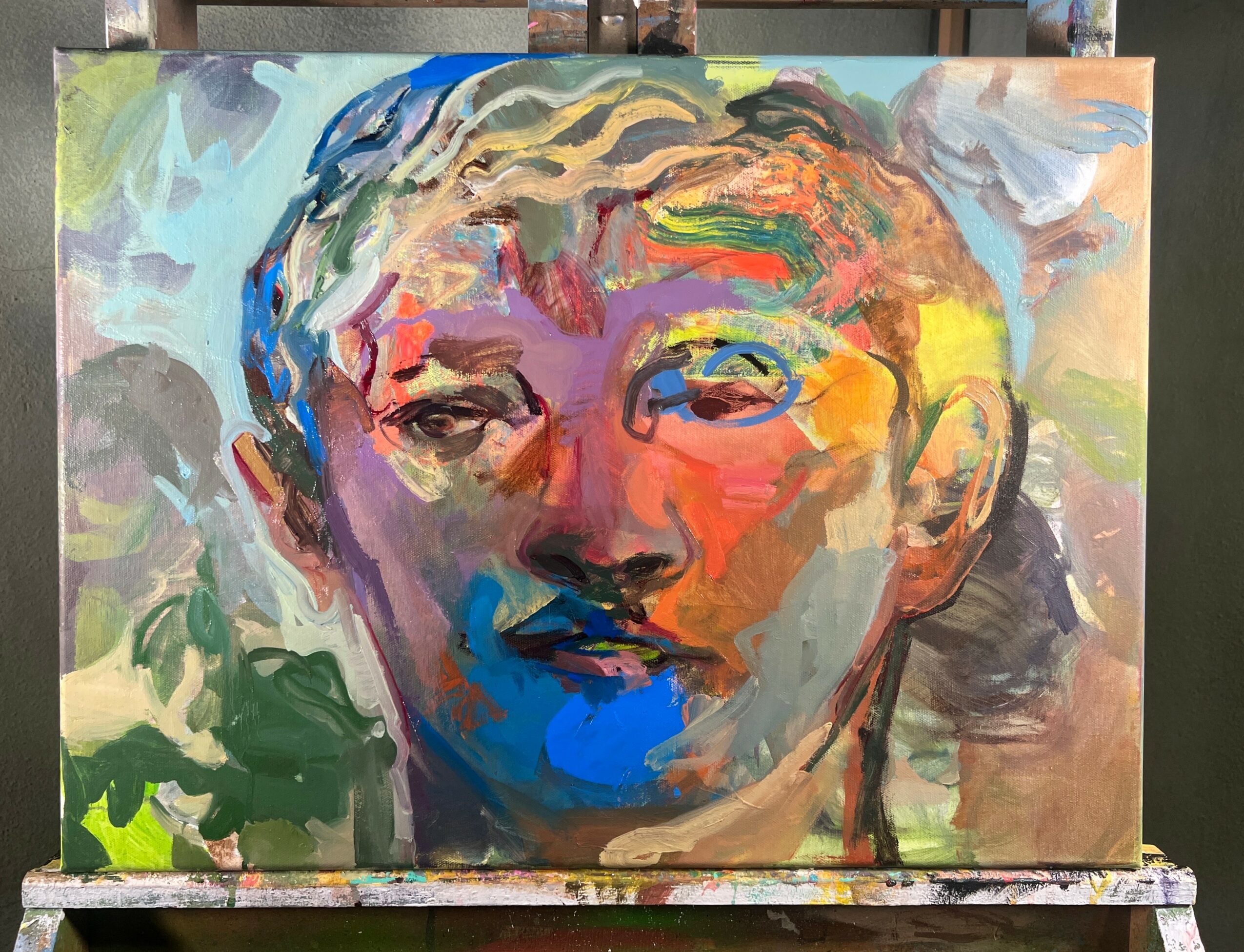 Abstract portrait of a person's face with colorful brushstrokes, facing slightly to the right, on a canvas.