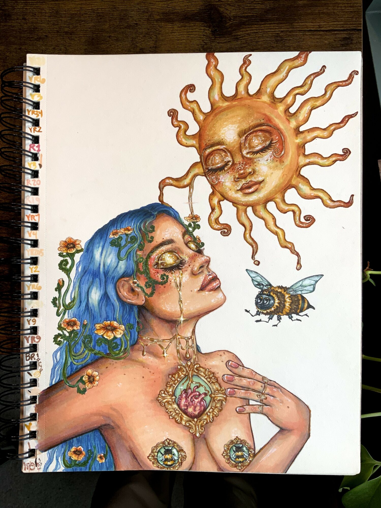 A woman with blue hair, adorned with flowers, has a sun with a face above her, a butterfly nearby, and jewelry on her chest and hand.